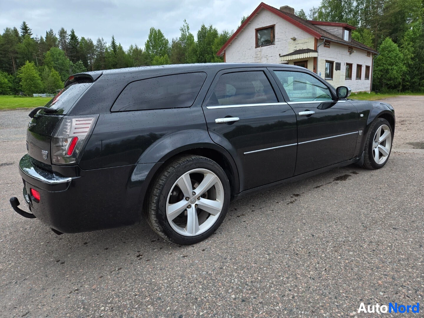Takaviisto: Musta Chrysler 300C farmari oikealta sivulta takaviistosta kuvattuna.