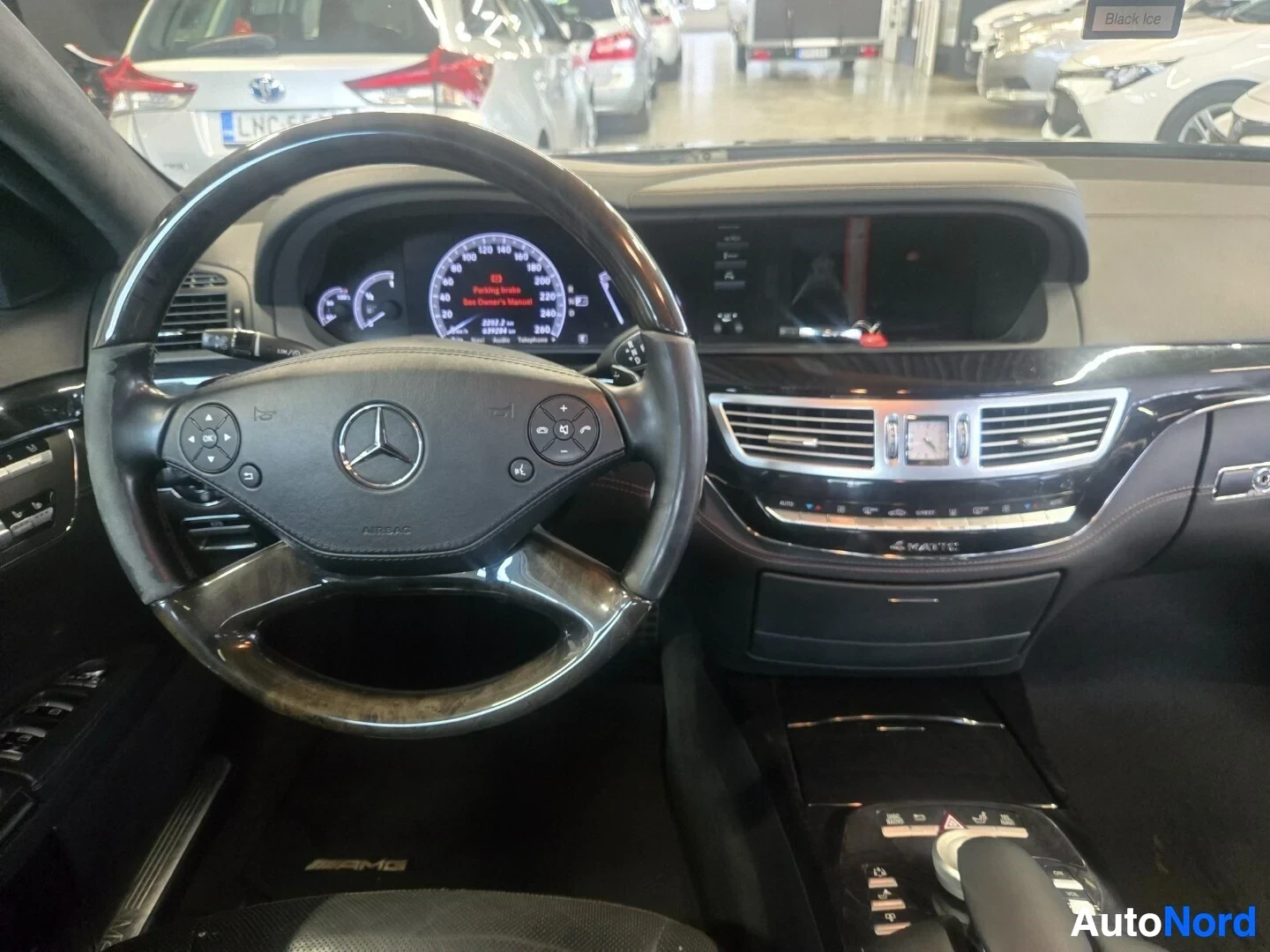 Ohjaamo: Kuva auton ohjaamosta kuljettajan paikalta. Kuvassa näkyy ohjauspyörä, jossa on Mercedes-Benz-logo ja monitoimipainikkeet, digitaalinen mittaristo, keskikonsoli