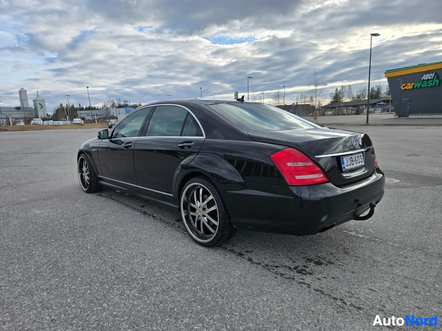 Takaviisto: Musta auto, jossa näkyvät takapuskuri, peräluukku, takavalot ja oikea kylki. Autossa on vetokoukku ja monipuolaiset kevytmetallivanteet. Rekisterikilpi on