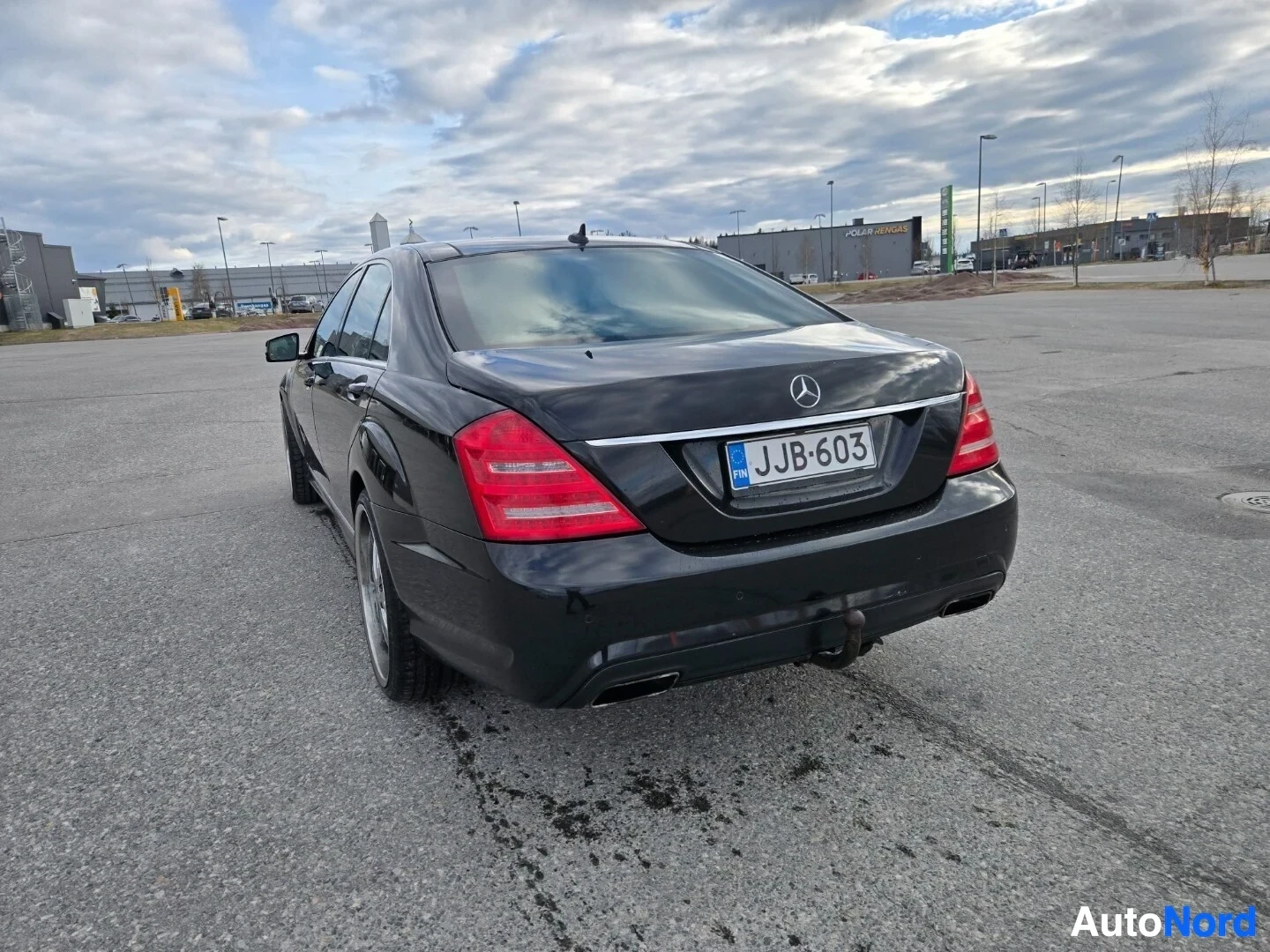 Takaviisto: Musta auto, jossa näkyy auton peräosa ja oikea takakulma. Autossa on vetokoukku ja rekisterikilpi