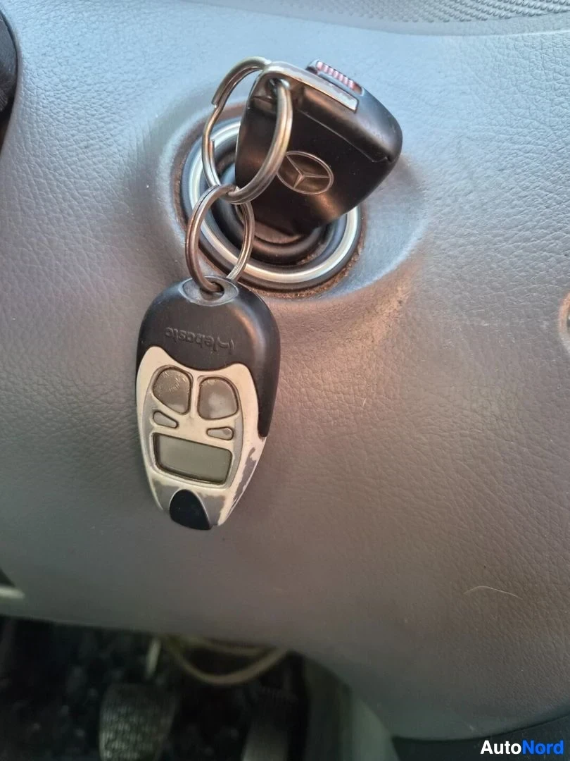 Yksityiskohta: Lähikuva avaimesta virtalukossa. Avaimessa on Mercedes-Benzin logo ja mukana on myös toinen avaimenperä, jossa lukee "telematic".