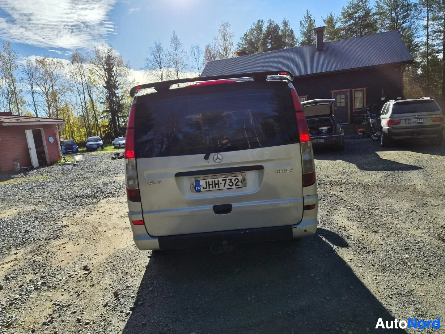 Takaa: Hopeanvärinen pakettiauto takaa kuvattuna. Rekisterikilpi on näkyvissä. Tummat takalasit ja spoileri takaluukussa