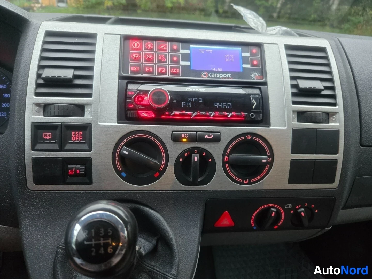 Ohjaamo: Kuva auton kojelaudasta ja keskikonsolista. Ilmastoinnin säätimet, Pioneer-merkkinen autoradio ja C Carsport -näyttö ovat näkyvissä. Vaihdekeppi on kuvassa etua