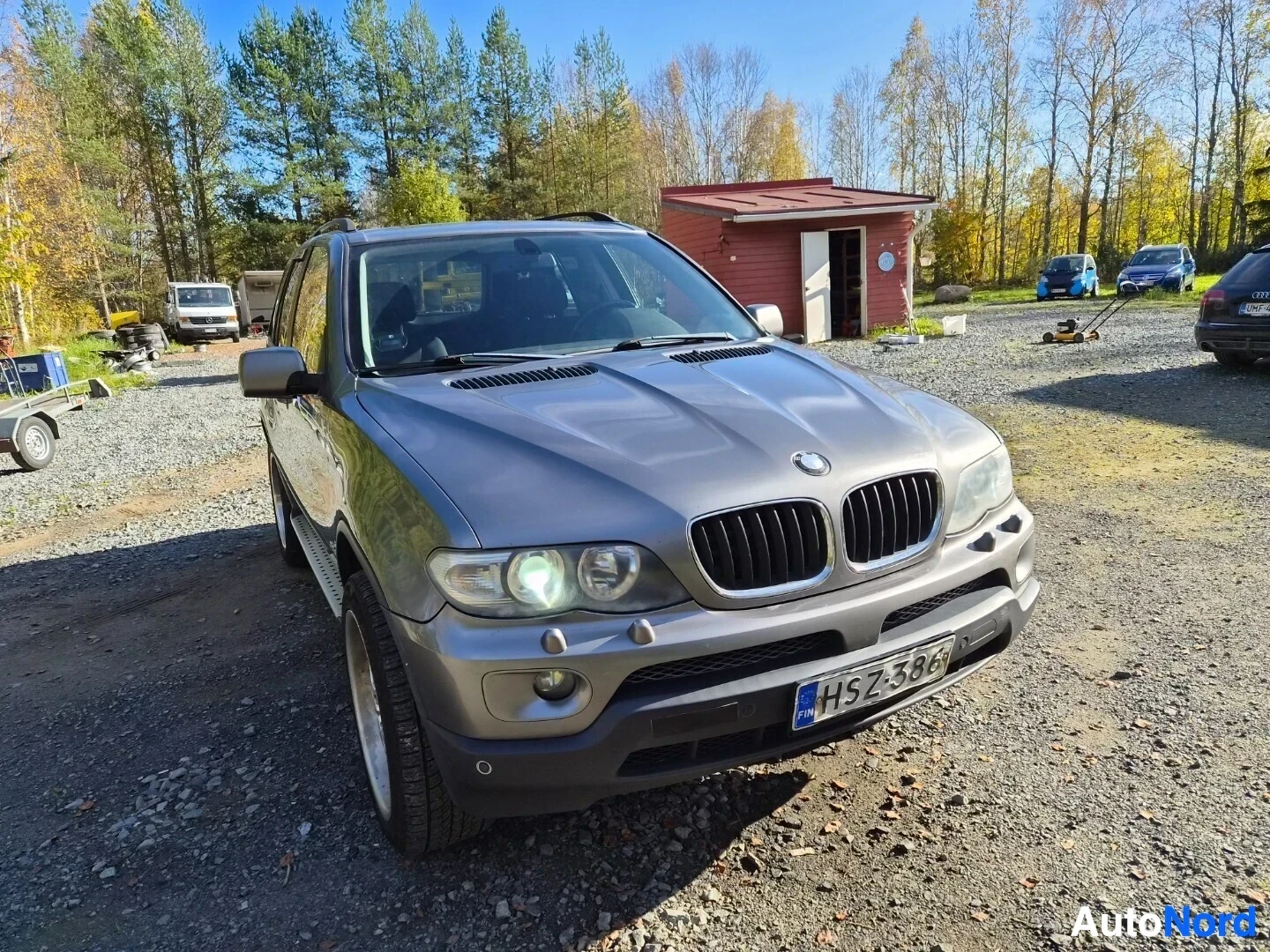 Etuviisto, nokka oikealle: Harmaa SUV pysäköitynä sepeliselle pihatielle, edestä ja oikealta edestäpäin kuvattuna. Rekisterikilpi on näkyvissä