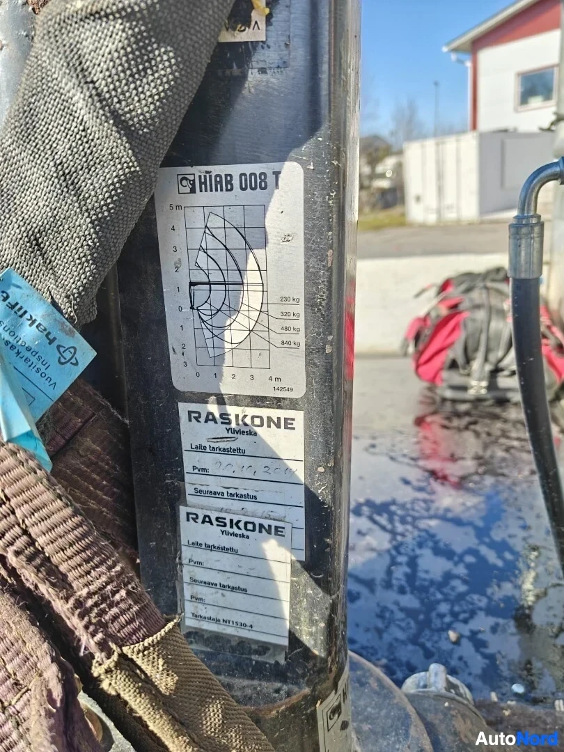Yksityiskohta: Tarra nosturin varressa. Tarrasessa näkyy diagrammi, jossa on nostokapasiteetti ja toimintaetäisyys. Siinä on myös tekstiä, kuten "RASKONE" ja "Ylivieska".