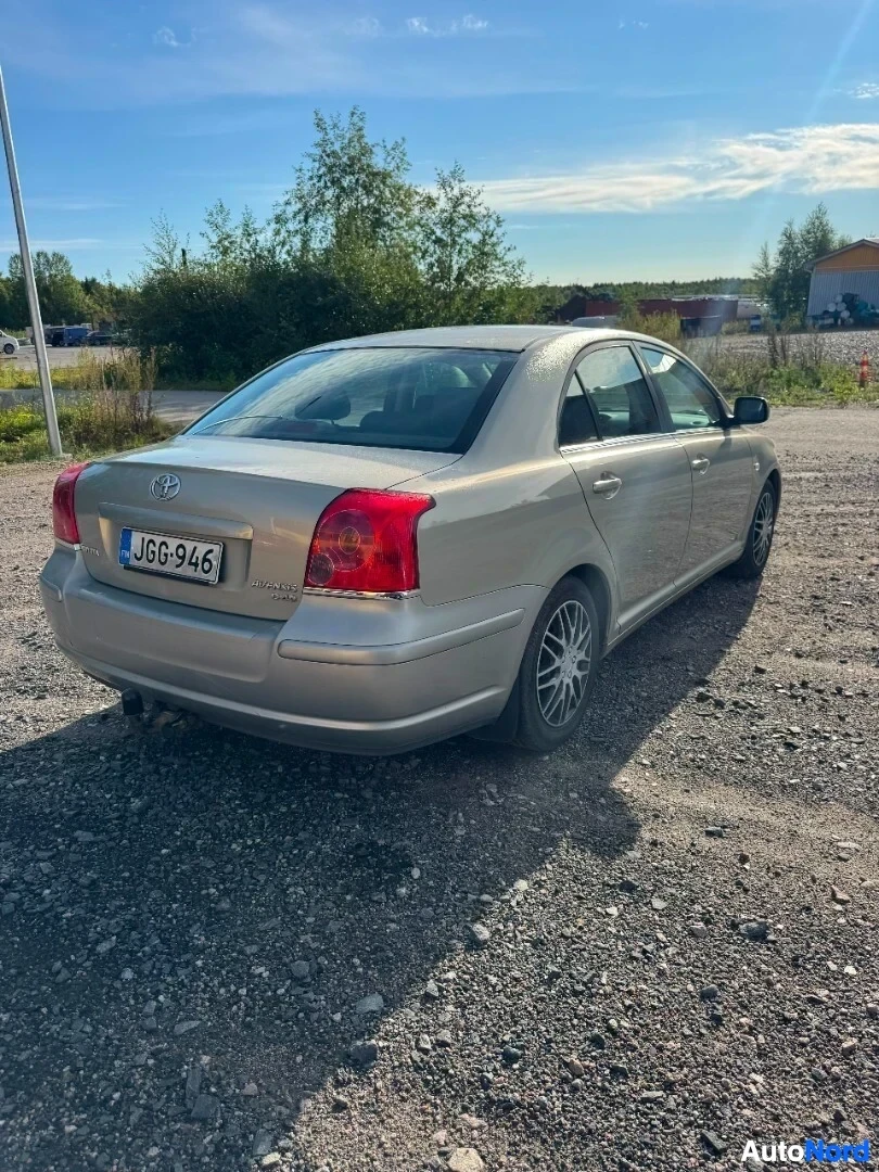 Takaviisto: Vaalea henkilöauto pysäköitynä sorapintaiseen pihaan. Auton takaosa ja vasen kylki ovat kuvassa. Rekisterikilvessä lukee