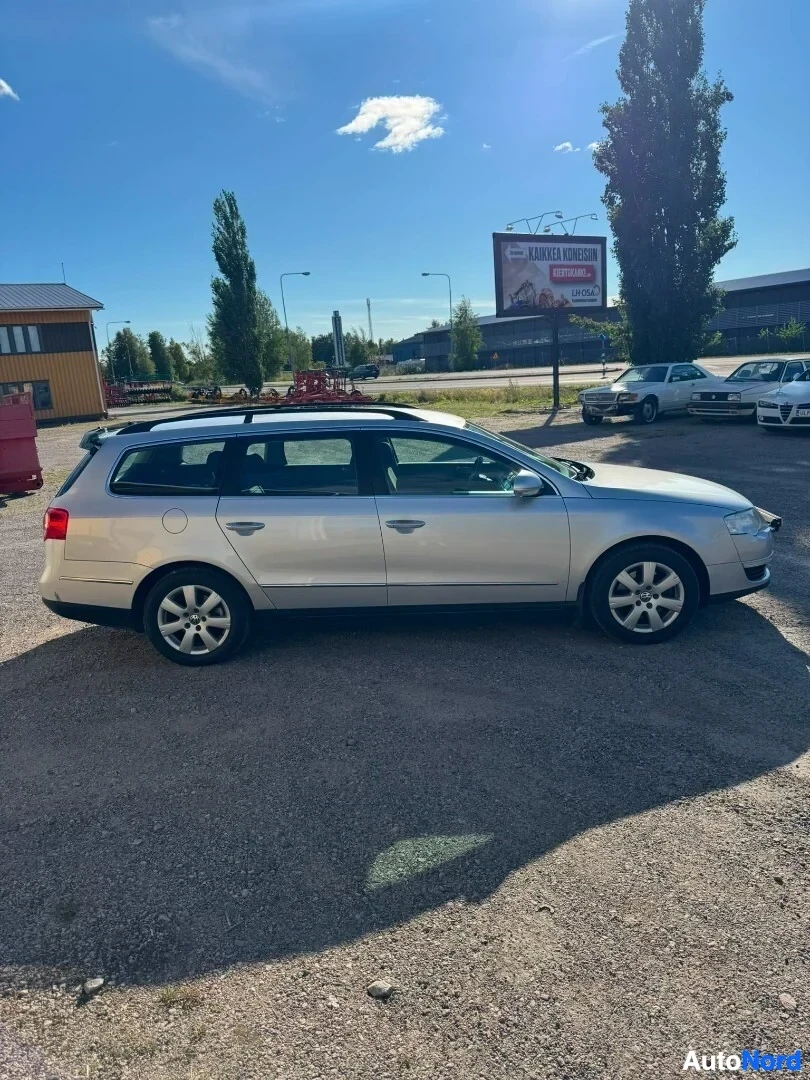 Sivulta: Hopeinen Volkswagen Passat Variant -farmariauto kuvattuna oikealta sivulta soraparkkipaikalla. Ajoneuvossa on kattokaiteet.