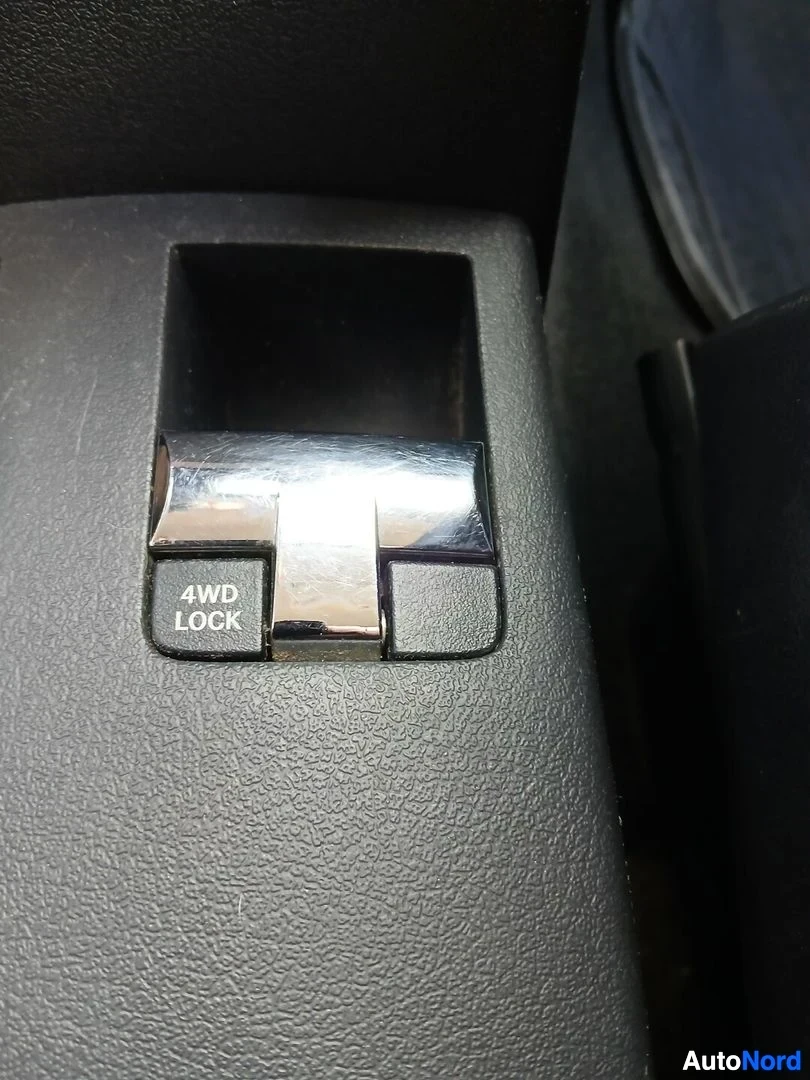 Yksityiskohta: Lähikuva mustasta kytkimestä, jossa lukee "4WD LOCK".