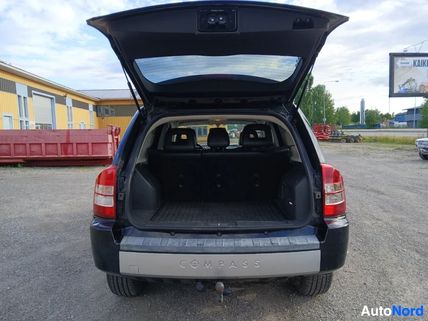 Takaa: Takaa kuvattu musta SUV, jonka takaluukku on auki, paljastaen tavaratilan ja takaistuimet. Tavaratilan pohjalla on musta matto.