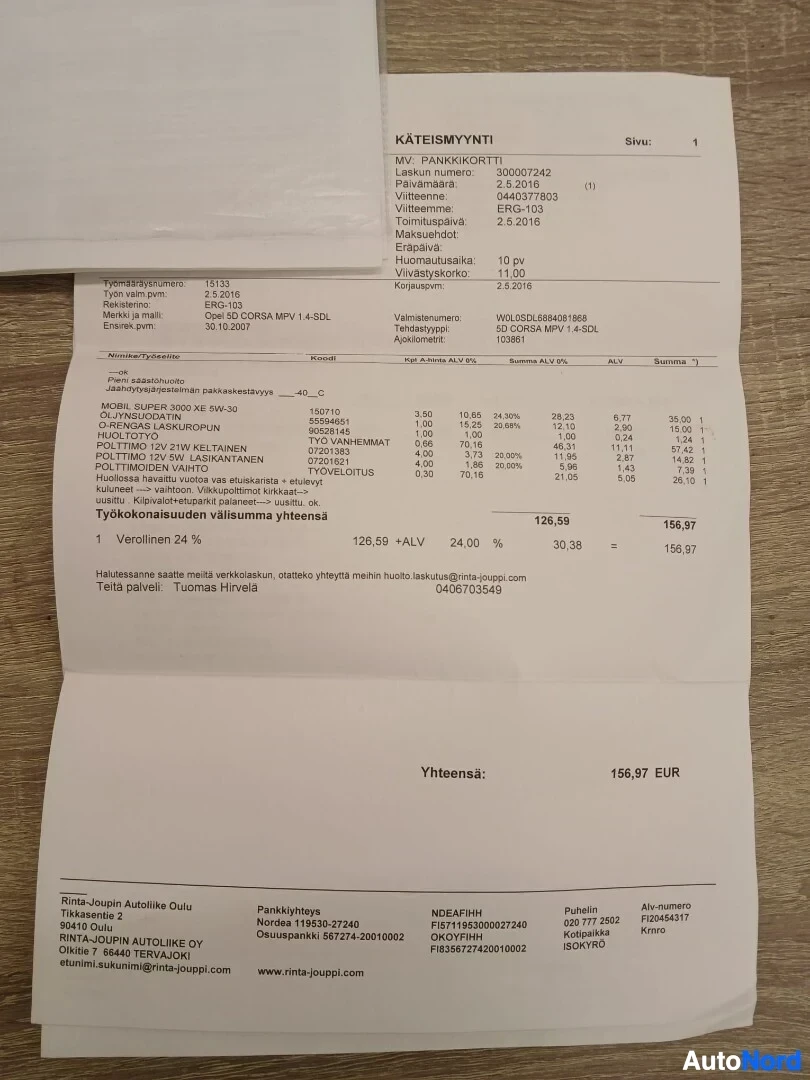 Asiakirja: Lähikuva huoltolaskusta tai kuitista, joka on osittain taitettu ja makaa lattialla. Asiakirjassa on tietoja auton huollosta ja maksetuista osista.