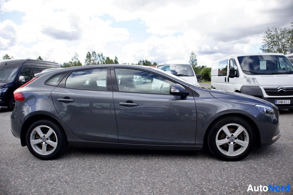 Sivulta: Harmaa henkilöauto sivulta päin kuvattuna asfalttipihalla. Ajoneuvossa on kevytmetallivanteet.