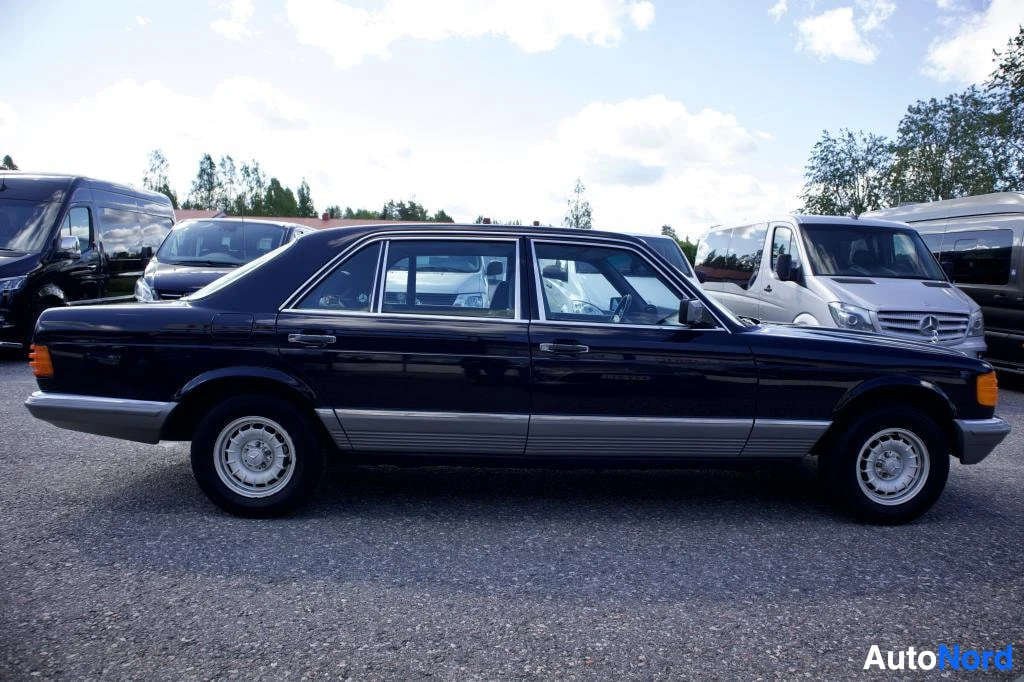 Sivulta: Tummansininen henkilöauto vasemmalta sivulta kuvattuna. Auton takarekisterikilpi on osittain näkyvissä.