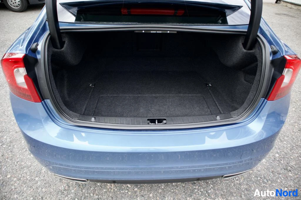 Takaa: Kuva auton takaosasta, jossa takakontti on auki. Auto on pysäköity asfaltille.
