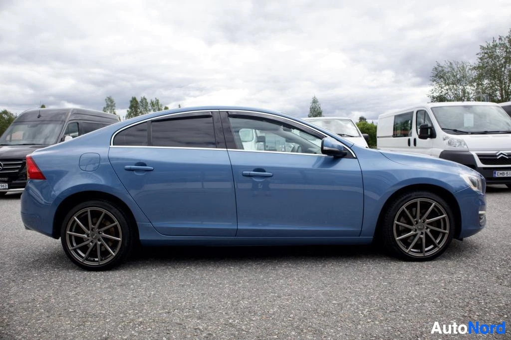 Sivulta: Sininen Volvo S60 kuvattuna suoraan sivulta parkkipaikalla.