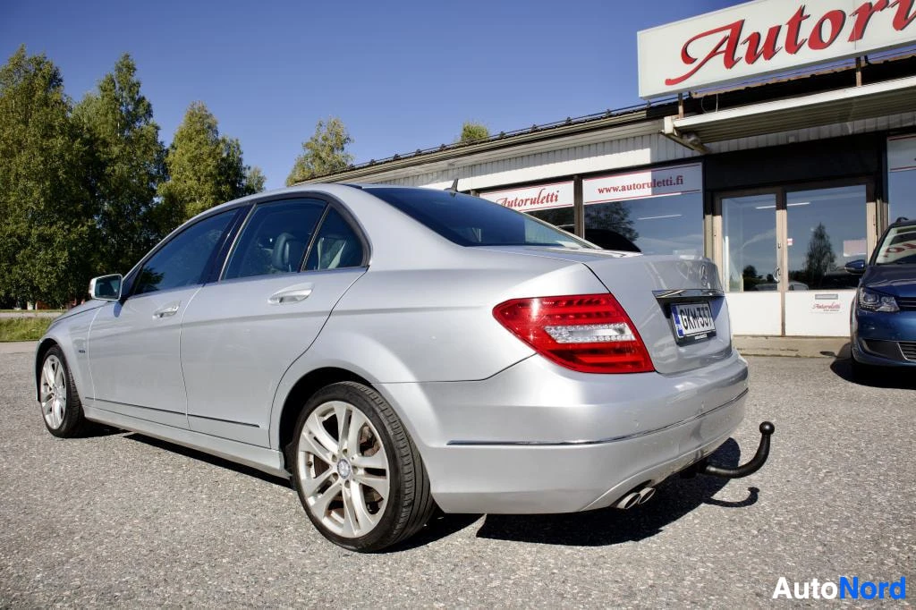 Takaviisto: Hopeanvärinen Mercedes-Benz C-sarjan sedanin takaosan kolmen neljänneksen kuva oikealta puolelta. Auton takarekisterikilvessä on teksti "" ja siinä on ve
