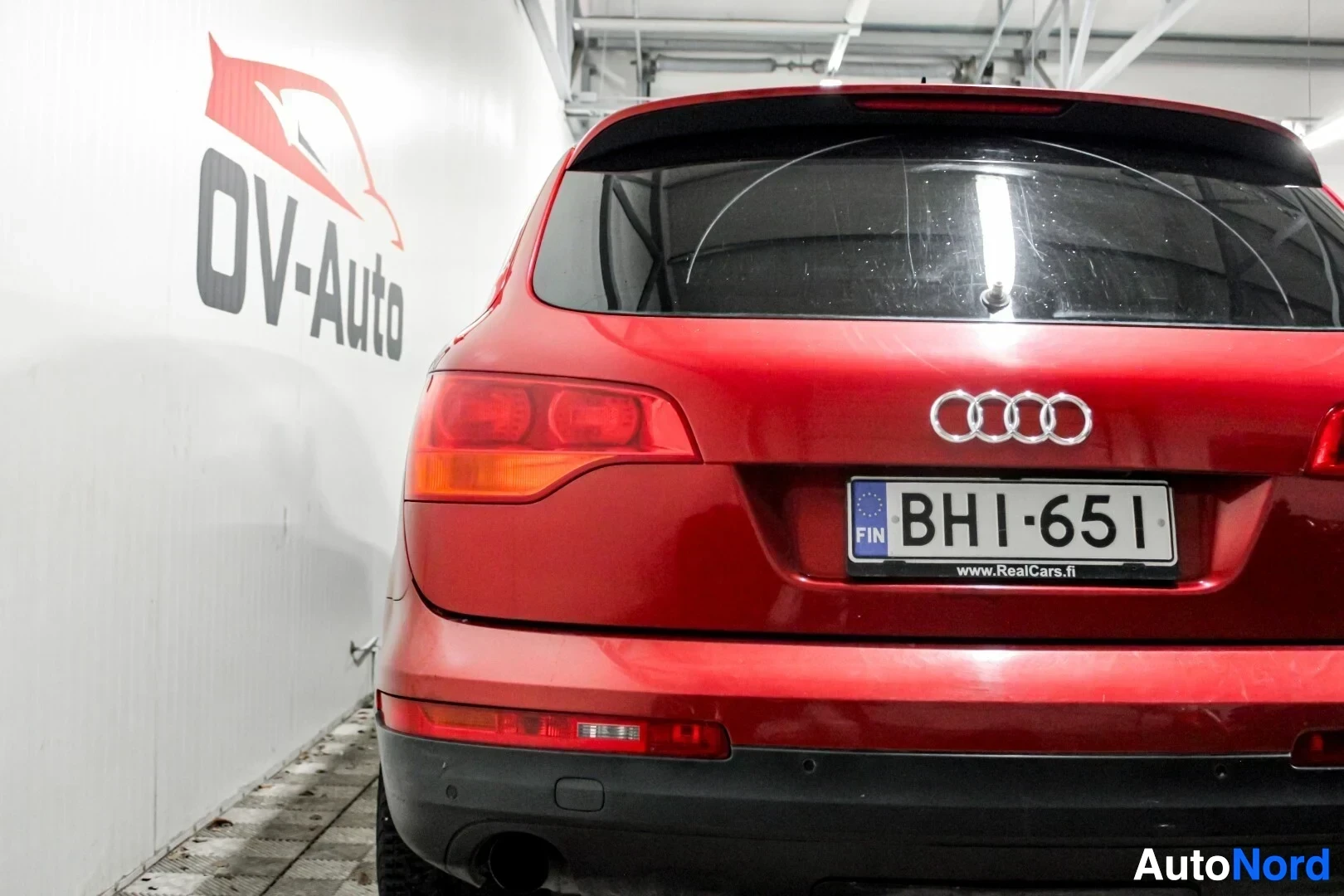 Takaa: Punaisen auton takaosa on kuvattu suoraan takaa. Takarekisterikilvessä lukee FIN ja alapuolella www.RealCars.fi. Takapuskurissa on kaksi pysäköintiantur
