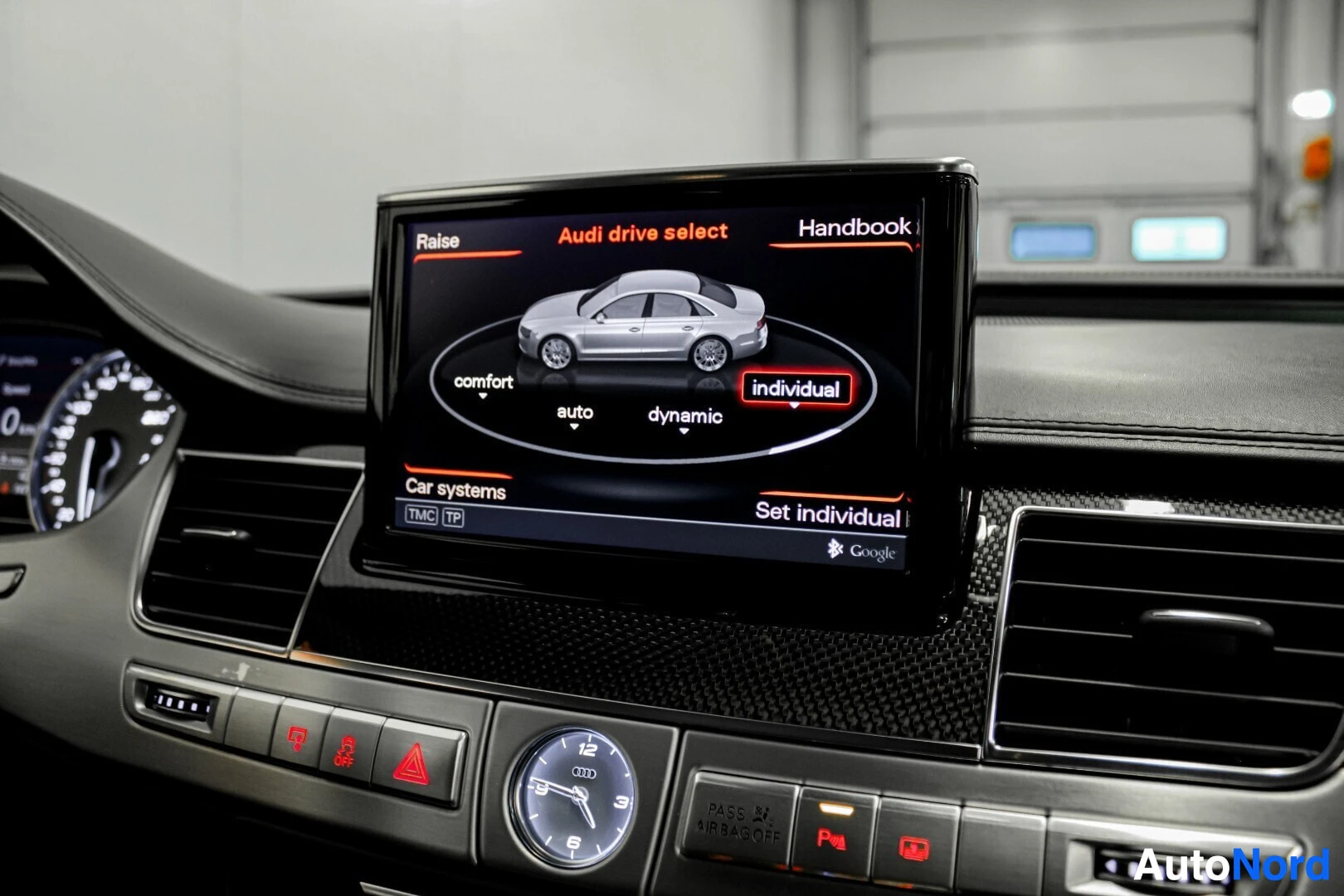 Yksityiskohta: Näyttöruutu, jossa näkyy Audi Drive Select -valikko, ja kojelauta.
