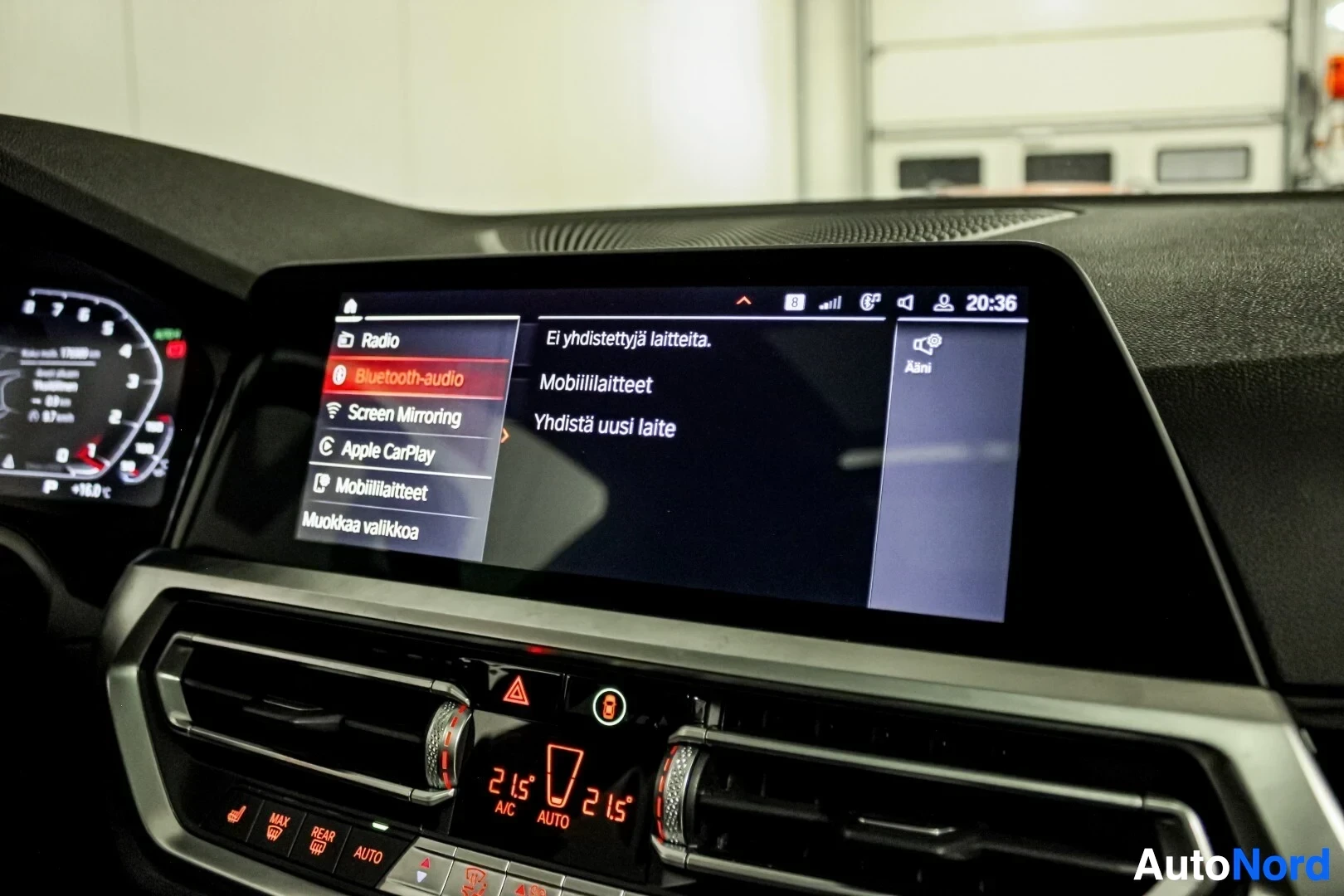 Ohjaamo: Ajoneuvon multimediajärjestelmän näytöllä on asetukset-valikko, jossa näkyvät vaihtoehdot Radio, Bluetooth-audio, Screen Mirroring, Apple CarPlay, Mobiililaitte