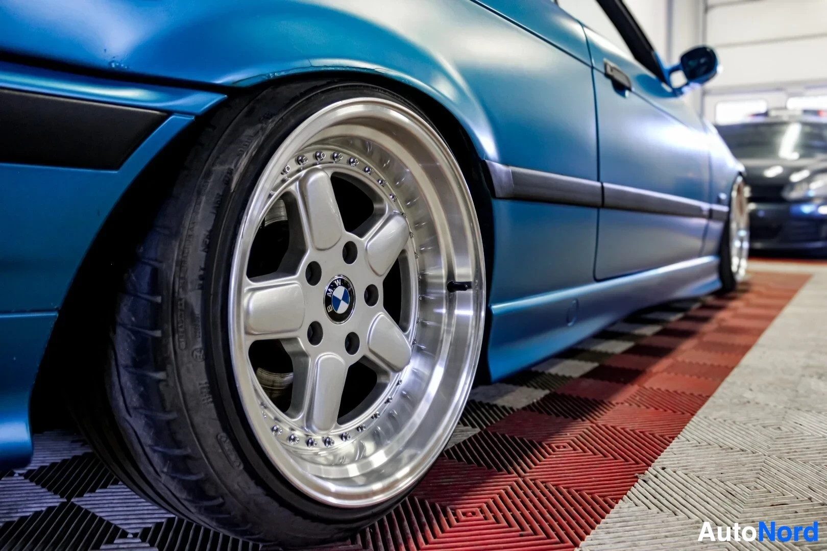 Yksityiskohta: Auton oikea etupyörä näkyy. Viisipuolaisessa vanteessa on BMW-logo keskellä. Vanteet ovat moniosaiset ja niissä on kiillotettu kehä.