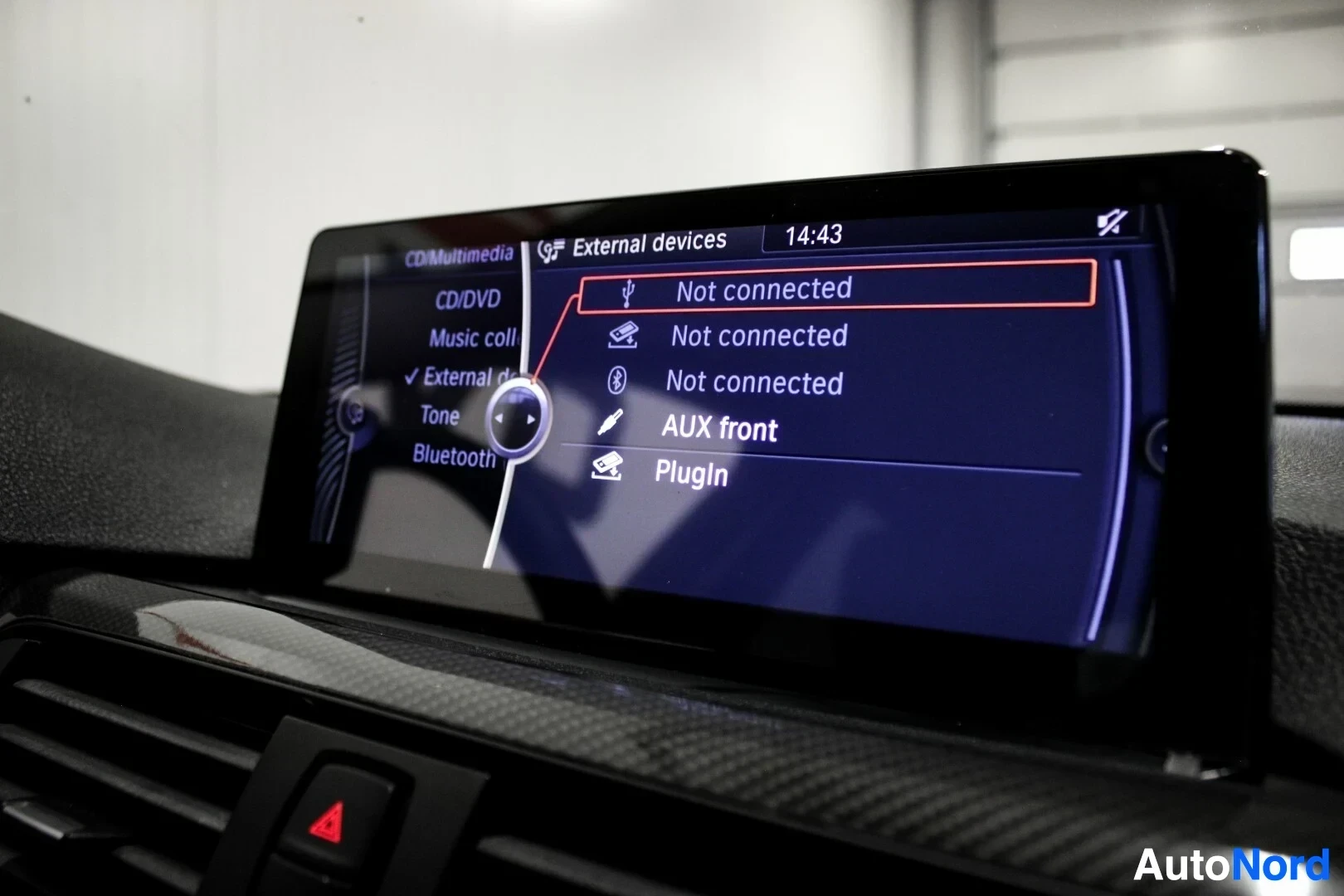 Yksityiskohta: Ajoneuvon infotainment-näyttö näyttää ulkoisten laitteiden valikon, jossa on vaihtoehdot USB, Bluetooth, AUX front ja Plugin.