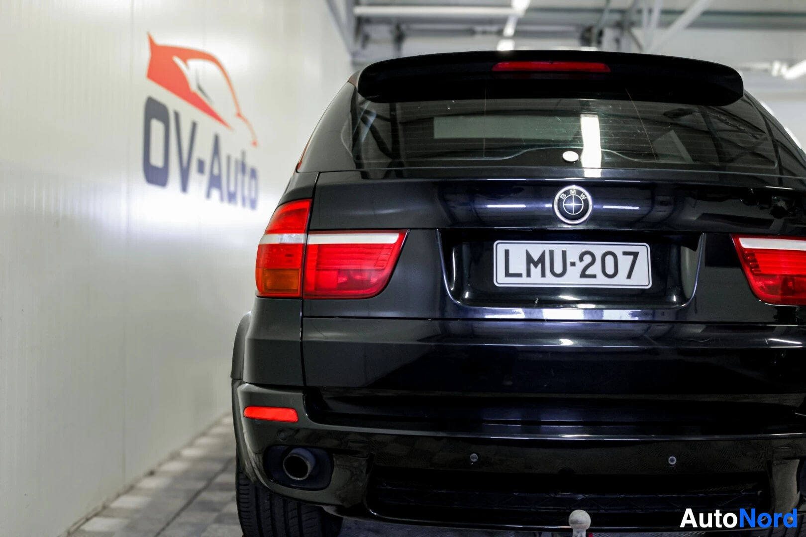Takaa: Mustan BMW X5 -auton takaosa on kuvattu sisätiloissa. Rekisterikilpi "" näkyy keskellä takaluukkua