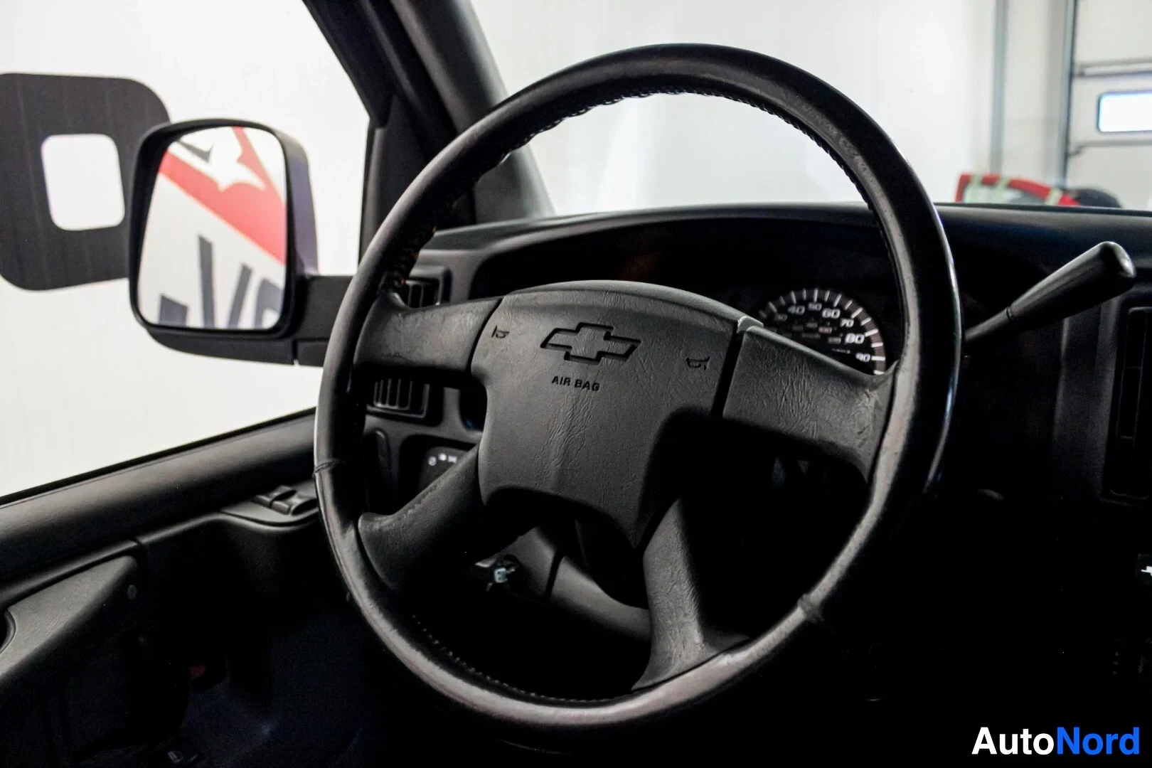 Ohjaamo: Lähikuva ohjauspyörästä ja mittaristosta, jossa näkyy nopeusmittari ja kierroslukumittari. Ohjauspyörän keskiössä on Chevroletin logo ja teksti "AIR BAG".