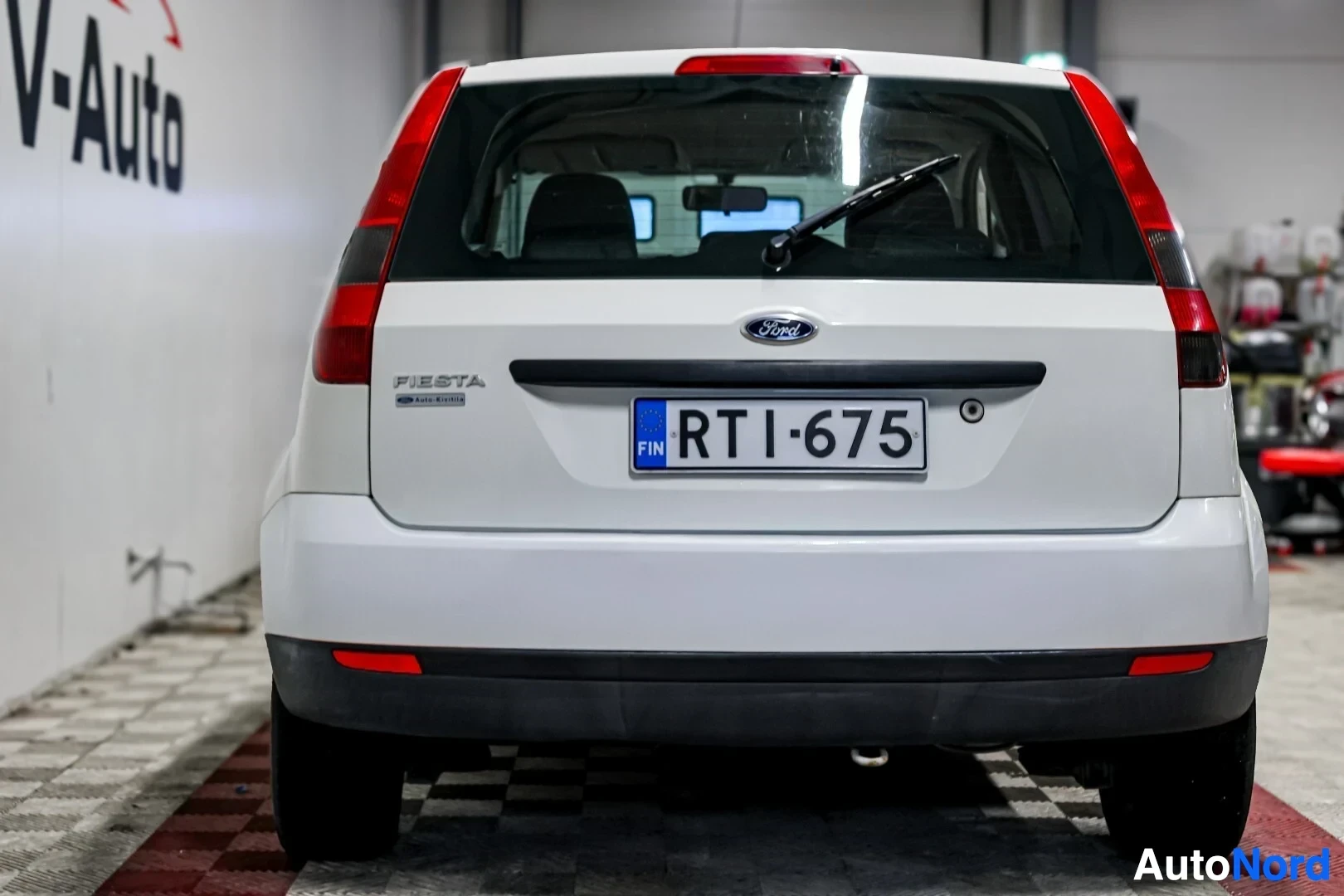 Takaa: Valkoinen Ford Fiesta kuvattuna suoraan takaa. Rekisterikilpi "" on luettavissa