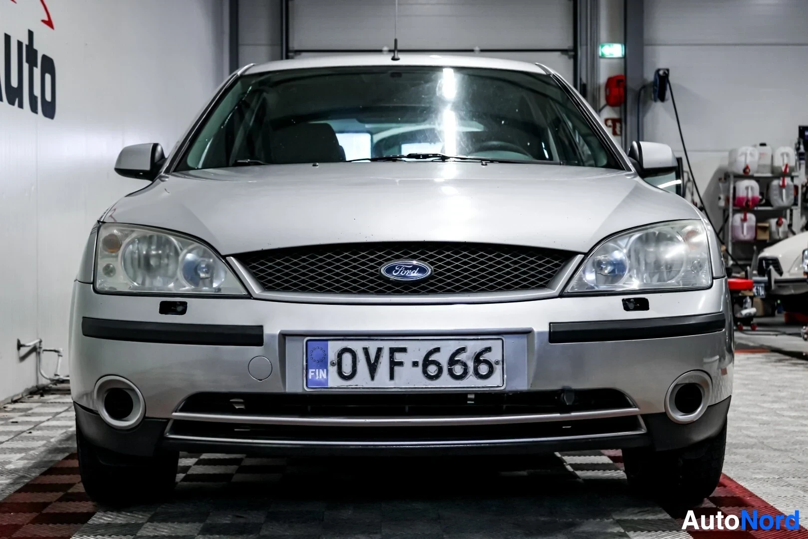 Edestä: Hopeanvärinen Ford Mondeo edestäpäin kuvattuna. Autossa on musta eturekisterikilpi