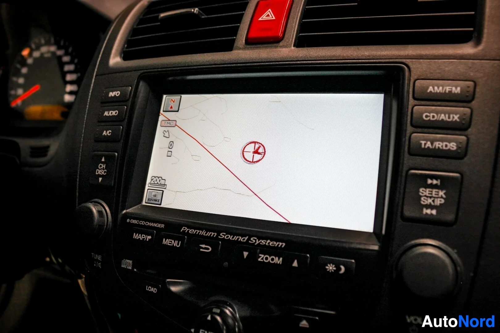 Yksityiskohta: Kuva auton infotainment-näytöstä, jossa näkyy navigaatiojärjestelmän karttanäkymä ja nuoli osoittaa kohteeseen.