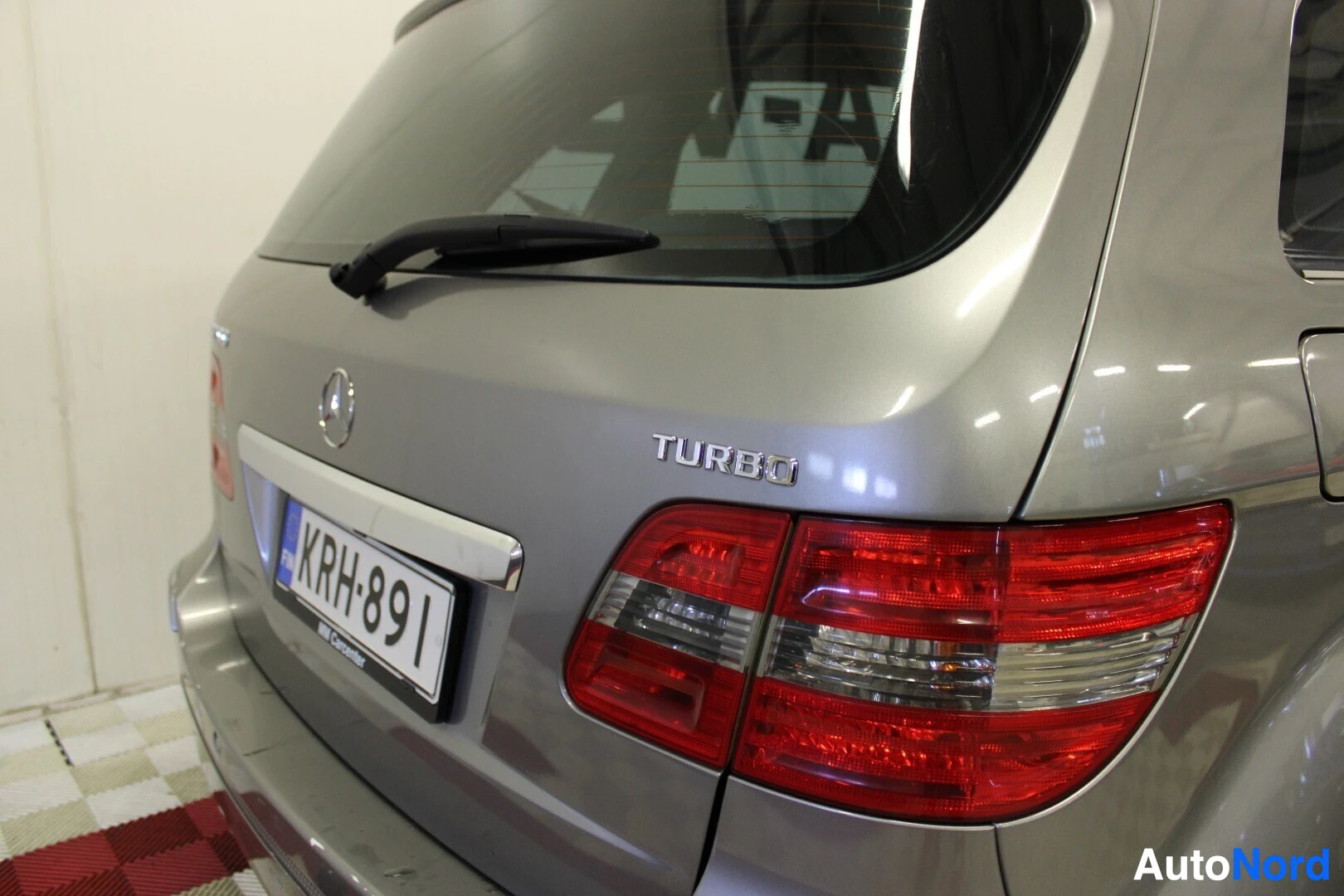 Takaviisto: Harmaan auton oikea takakulma, jossa näkyy takavalo, takaluukku ja rekisterikilpi "". Takaluukussa on myös teksti "TURBO"