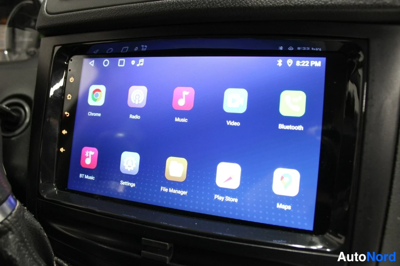 Yksityiskohta: Lähikuva auton kosketusnäytöstä, jossa näkyy sovellusvalikko. Sovelluksia ovat Chrome, Radio, Music, Video, Bluetooth, BT Music, Settings, File Manager, Play St