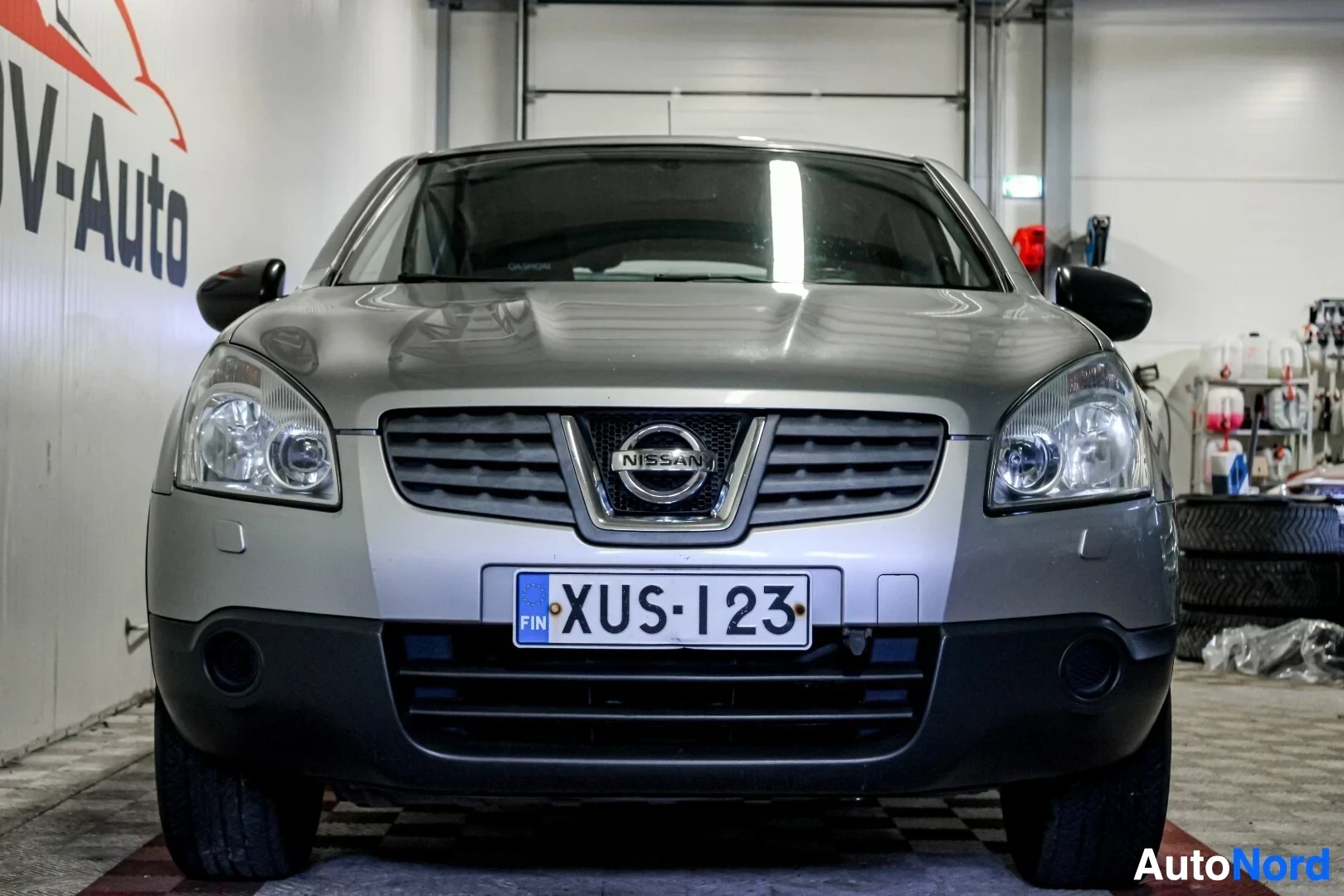 Edestä: Hopeanvärinen Nissan Qashqai edestä kuvattuna. Autossa on FIN-maatunnuksella varustettu rekisterikilpi ja Nissan-logo etusäleikössä