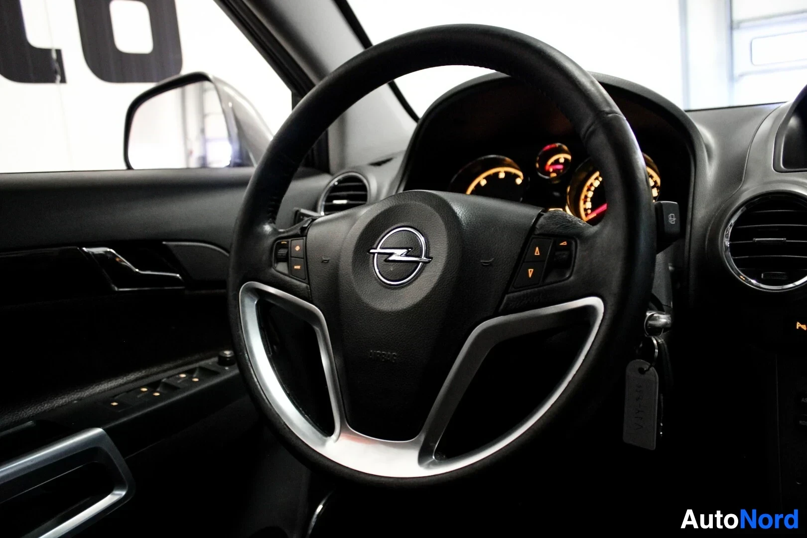 Yksityiskohta: Lähikuva ohjauspyörästä, jossa on Opel-logo ja monitoiminäppäimet.