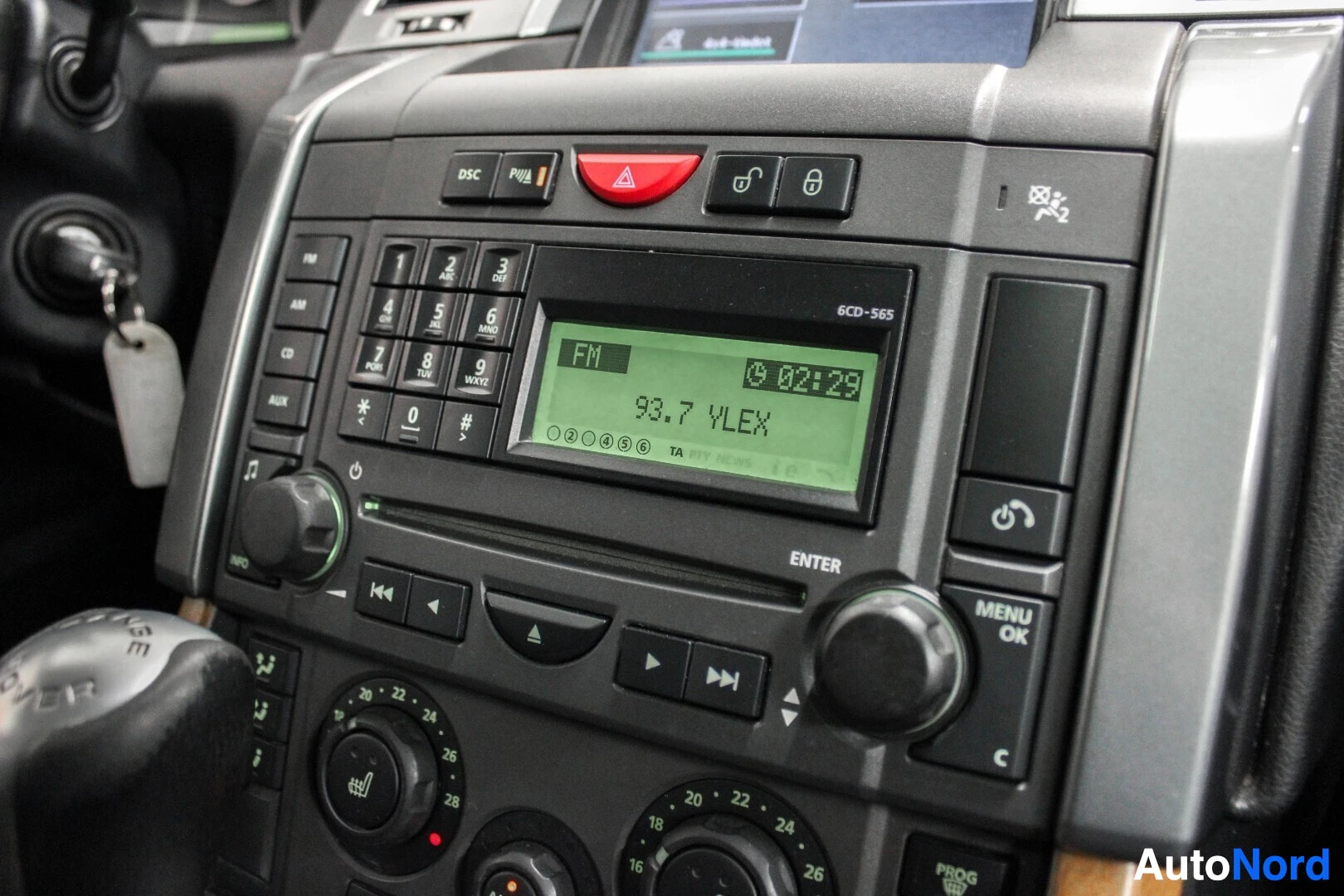 Ohjaamo: Keskikonsolin yläosa, jossa on radio/CD-soitin "93.7 YLEX" -tekstillä näytöllä. Ylempänä on "DSC PULL"-painike ja ovin lukituspainikkeet. Alueella on myös ilmas