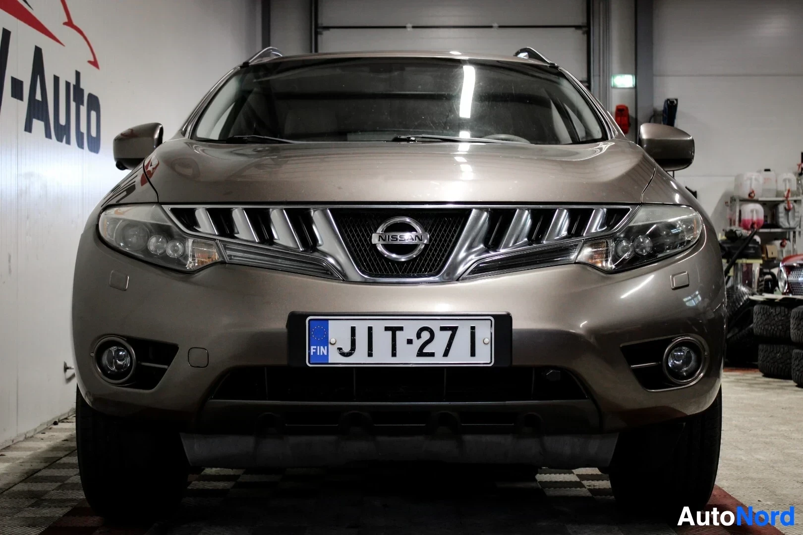 Edestä: Beige SUV:n etuosa kuvattuna edestä päin. Rekisterikilvessä on tunnus. Keulassa on kaksi sumuvaloa