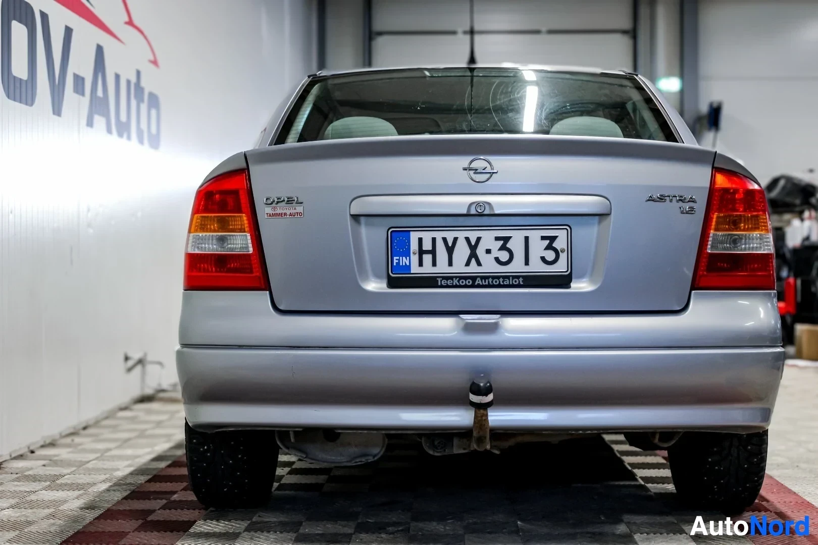 Takaa: Hopeanvärinen Opel Astra kuvattuna suoraan takaa. Autossa on vetokoukku.