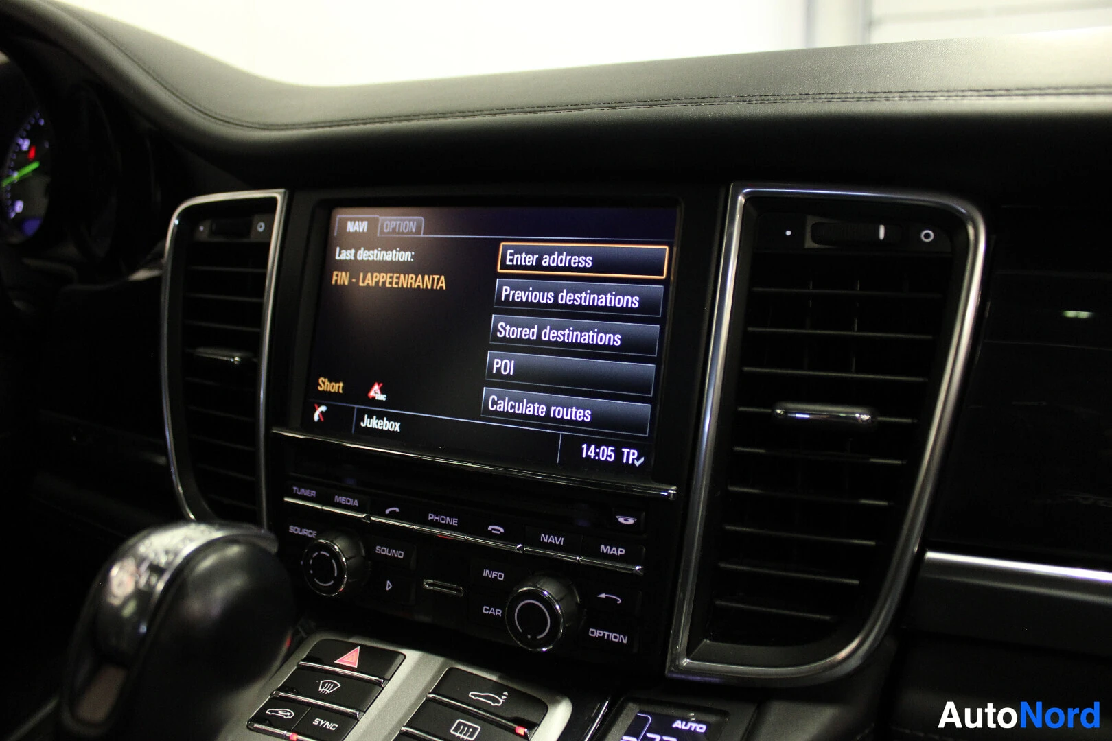 Ohjaamo: Kuva auton infotainment-näytöstä, jossa näkyy navigointivalikko ja vaihtoehdot kuten "Enter address", "Previous destinations", "Stored destinations", "POI" ja "