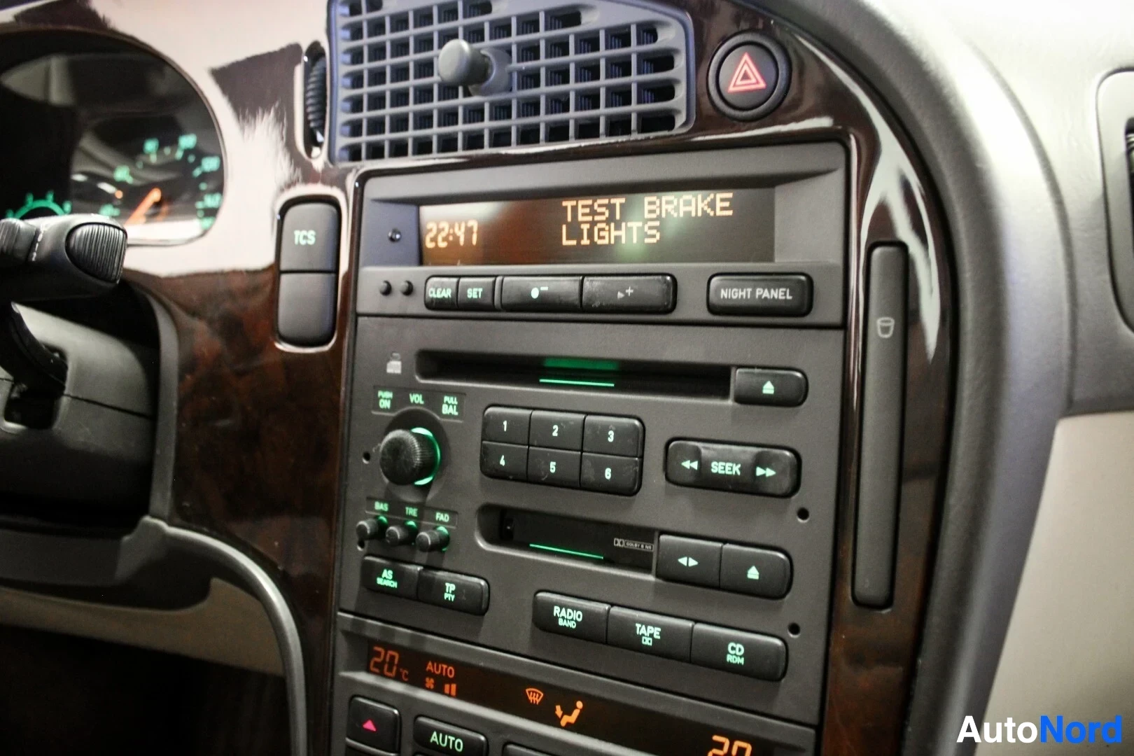 Ohjaamo: Lähikuva auton kojelaudan keskikonsolista, jossa on radio ja näyttö, jossa lukee "TEST BRAKE LIGHTS" sekä "22:47".