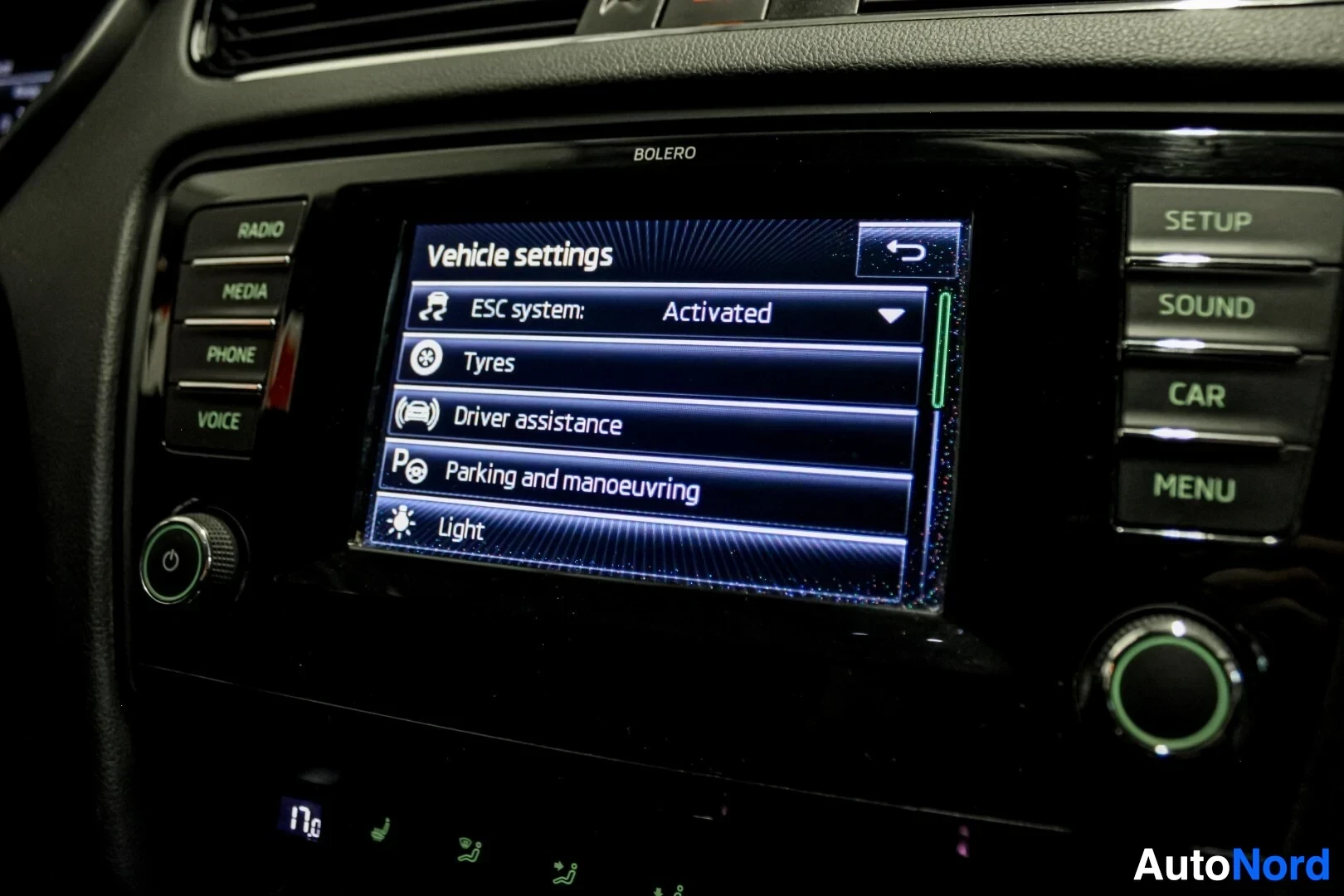 Yksityiskohta: Tietoviihdejärjestelmän näyttö, jossa näkyy "Vehicle settings" -valikko ja vaihtoehtoja, kuten "ESC system", "Tyres", "Driver assistance", "Parking and manoeuvr