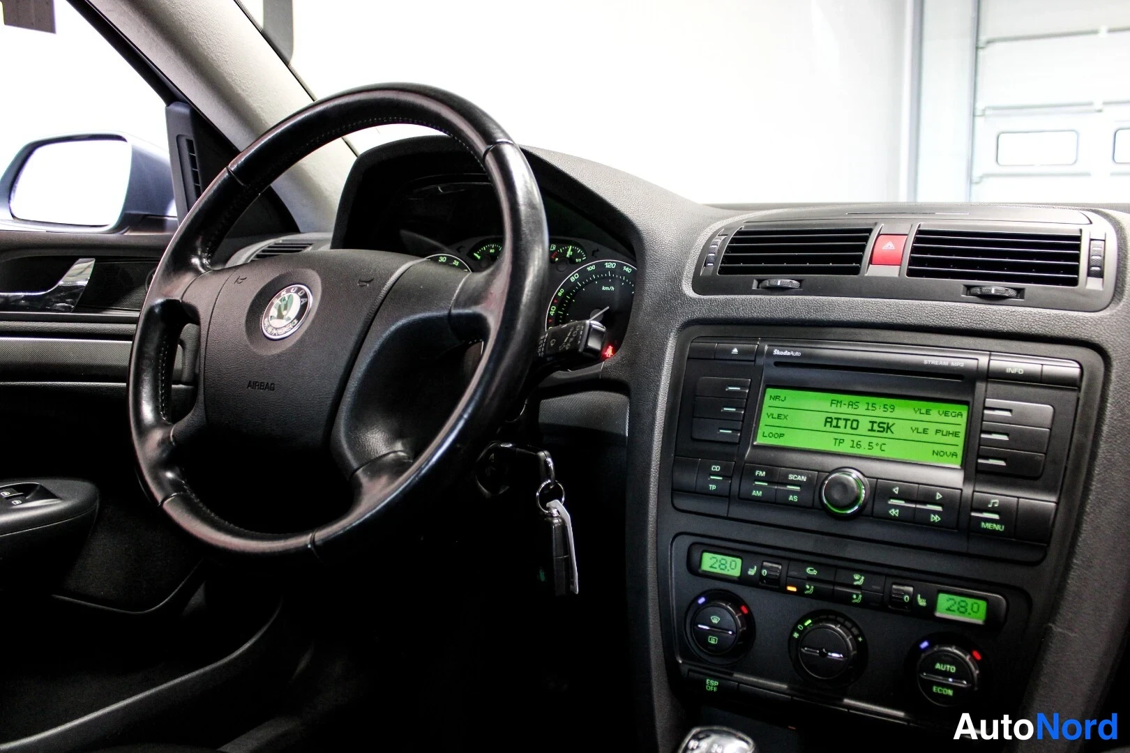 Muu: Ohjaamo vasemmalta: Škoda-ohjauspyörä, mittaristo, radio ja kaksikaupunkinen ilmastointipaneeli näkyvät.