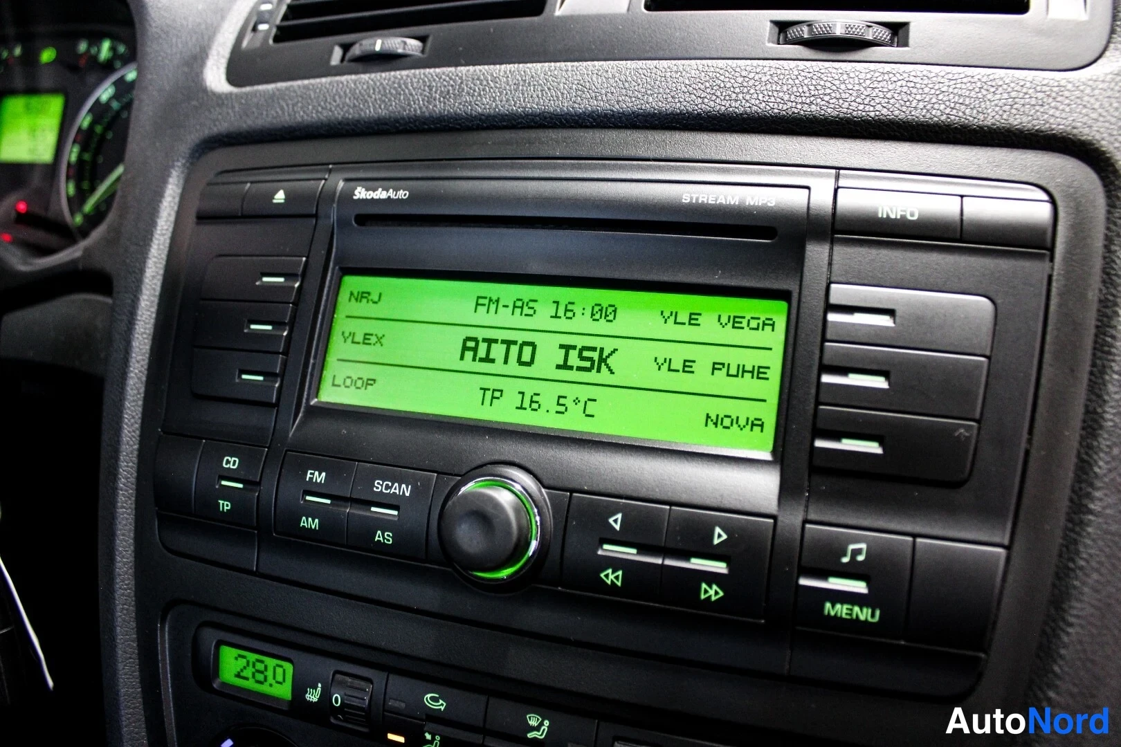 Muu: Kojelaudan radio lähikuvassa: Škoda Stream MP3 -yksikkö vihreällä näytöllä, tekstit NRJ FM-AS 16:00, AITO ISK, TP 16.5°C, NOVA.