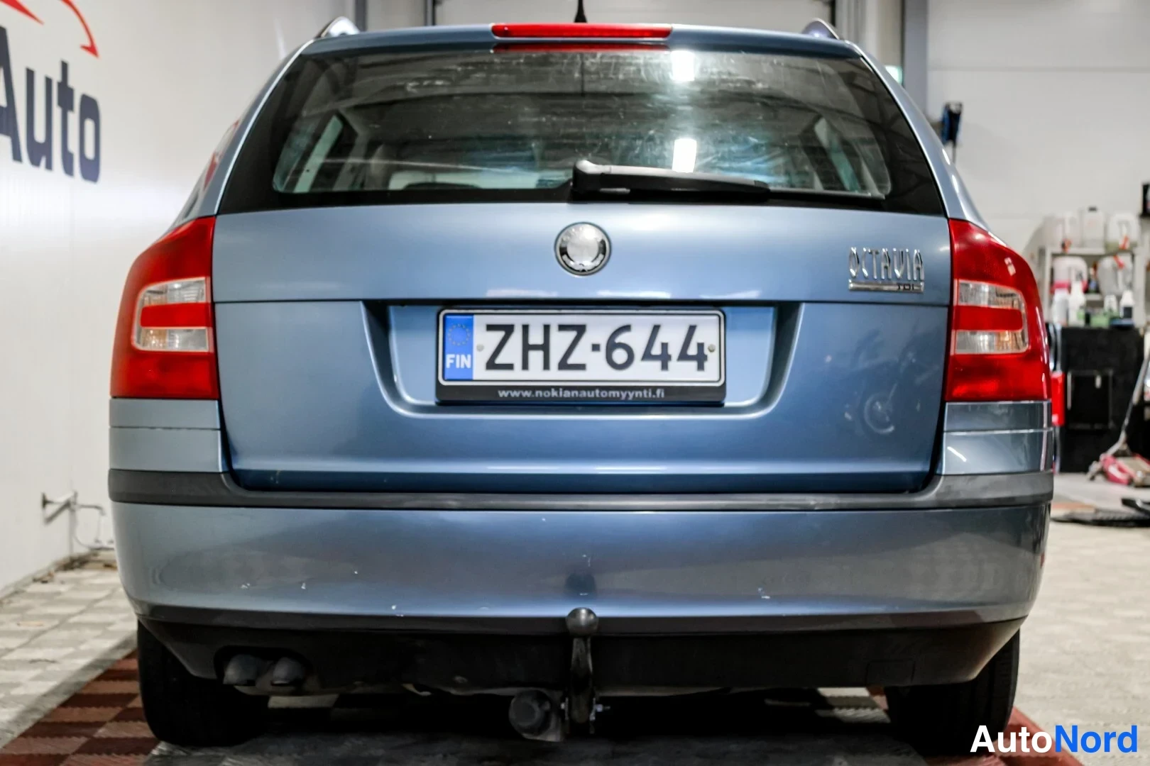 Takaa: Skoda Octavian perä suoraan takaa kuvattuna, Octavia-teksti ja rekisterikilpi, vetokoulu puskurin alla.