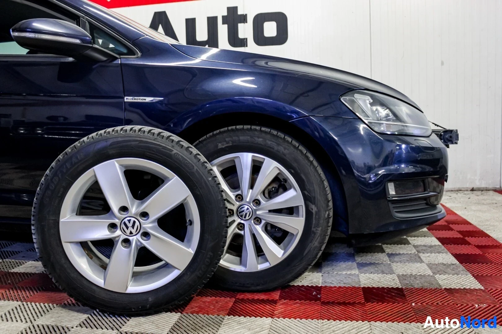 Etuviisto, nokka oikealle: Sivuprofiili tummansinisestä Volkswagen Golfista, jonka edessä on toiset renkaat, joissa on hopeiset viisipuolaiset vanteet ja talvirenkaat. Autossa on h