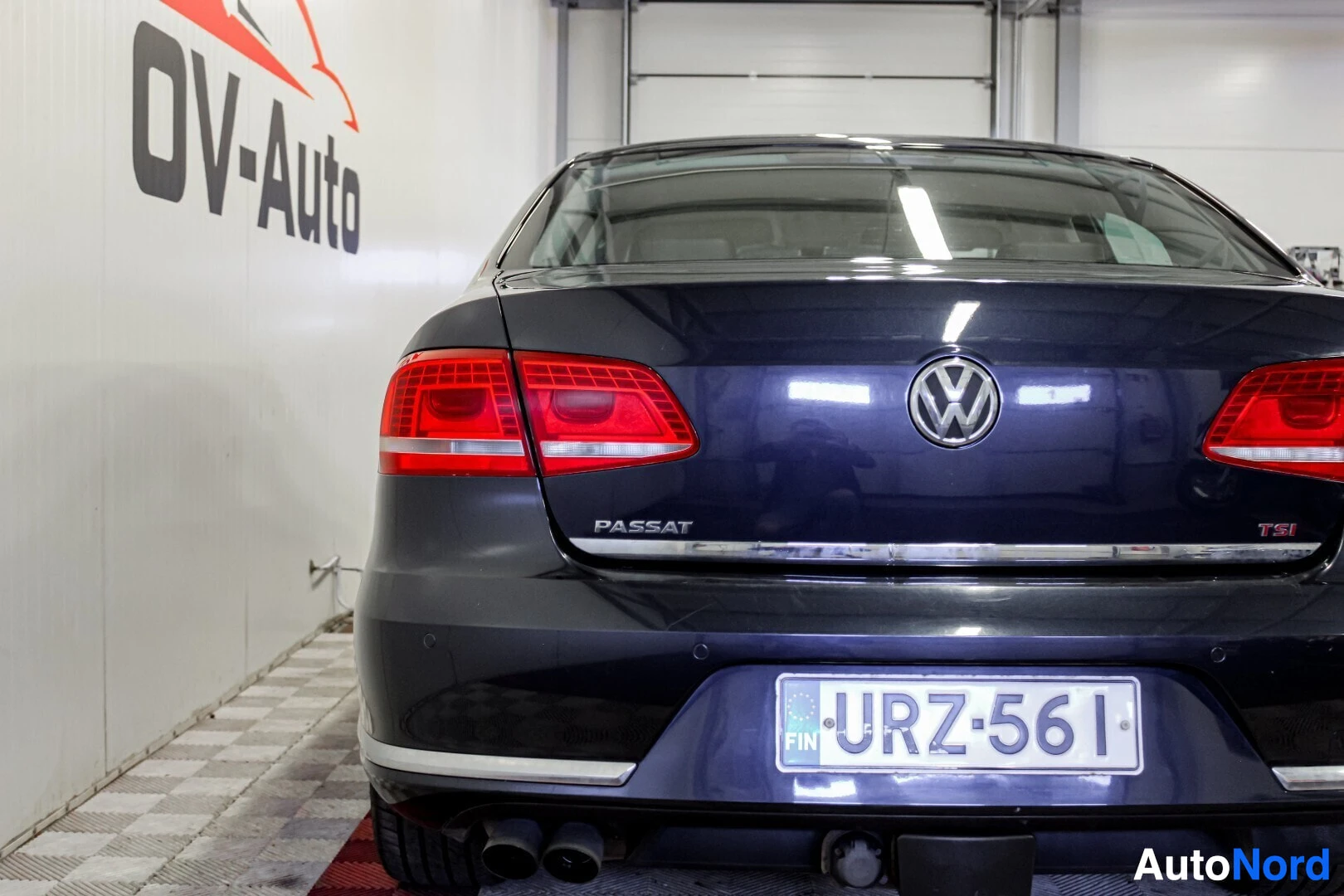 Takaa: Auton takaosa, takaluukussa tekstit "PASSAT" ja "TSI". Rekisterikilvessä teksti ""