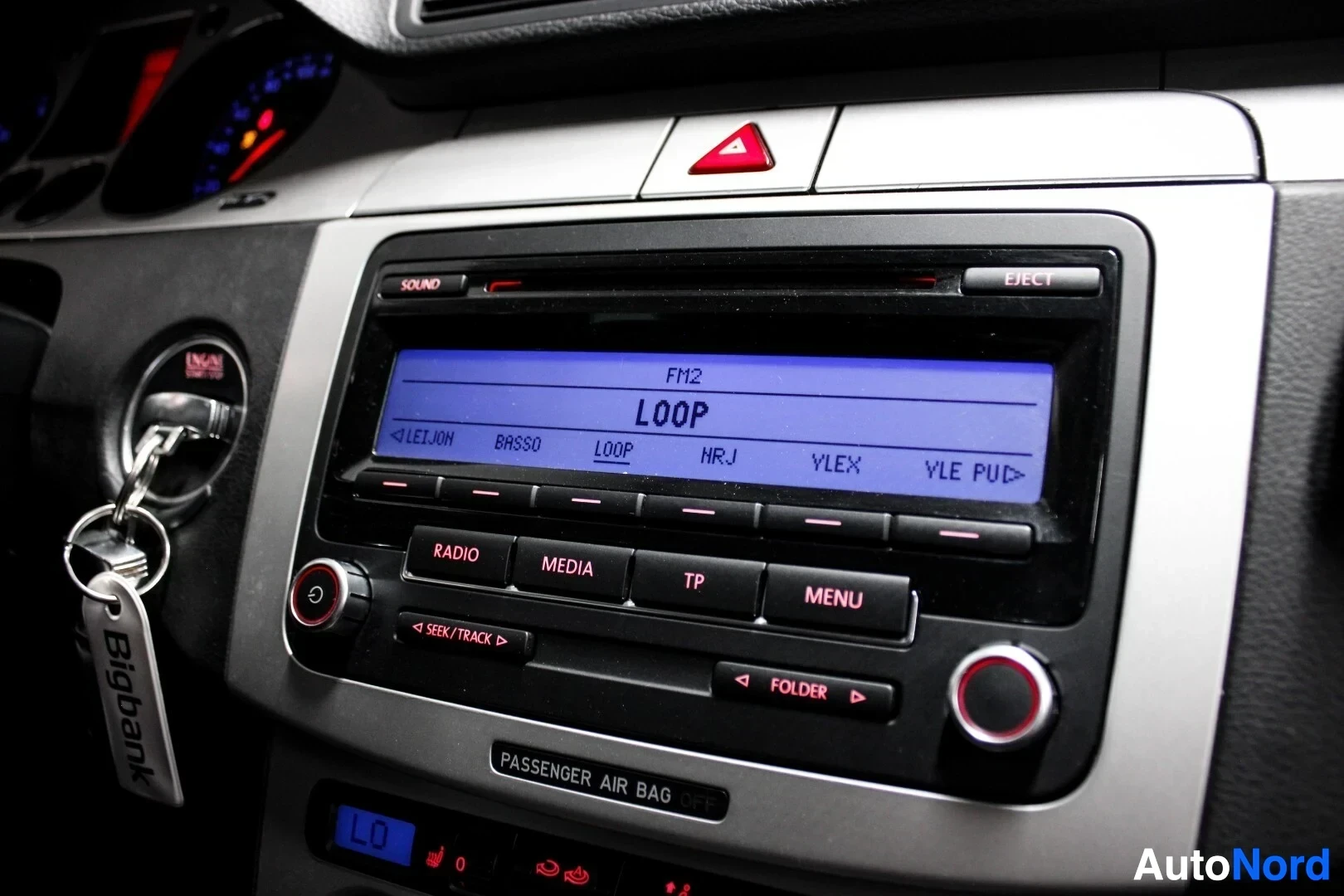 Yksityiskohta: Lähikuva auton keskikonsolista, jossa näkyy radio/CD-soitin sinisellä näytöllä, jossa lukee "FM2 LOOP".