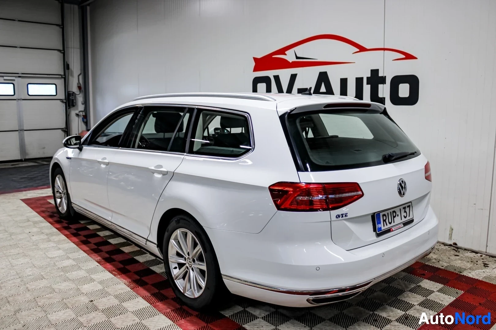 Takaviisto: Valkoinen Volkswagen Passat Variant GTE takavasemmalta kuvattuna OV-Auton myymälässä.