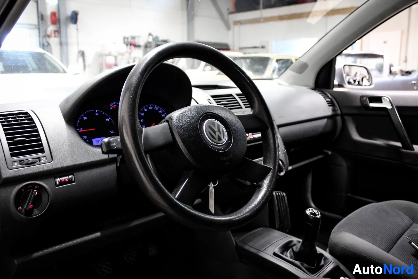 Ohjaamo: Ohjauspyörä Volkswagen-logolla, mittaristo ja käsivalintainen vaihdekeppi.