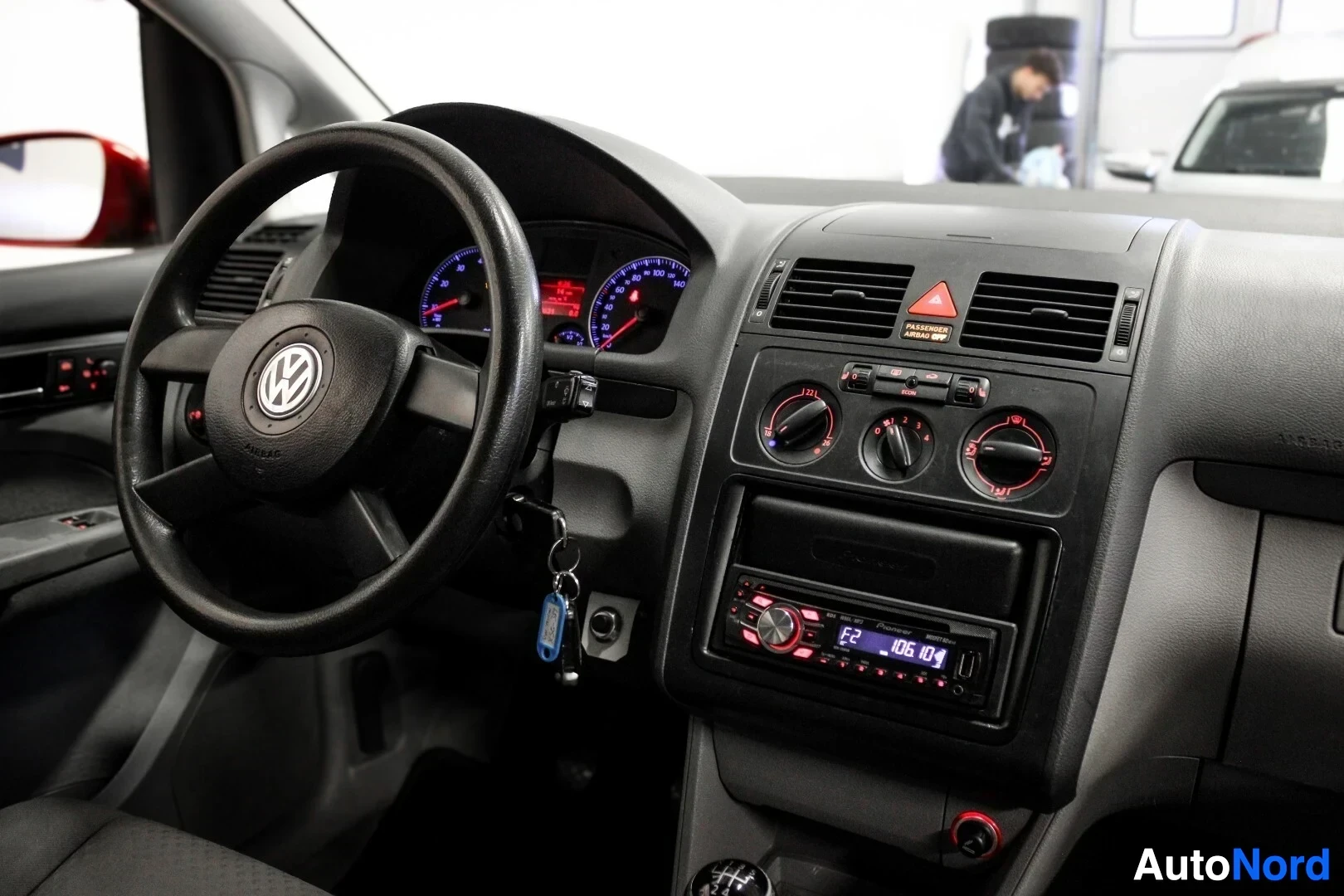Ohjaamo: Kojelauta ja ohjauspyörä, jossa on Volkswagen-logo keskellä. Kojelaudassa on Pioneer-merkkinen autoradio ja ilmastoinnin säätimet.