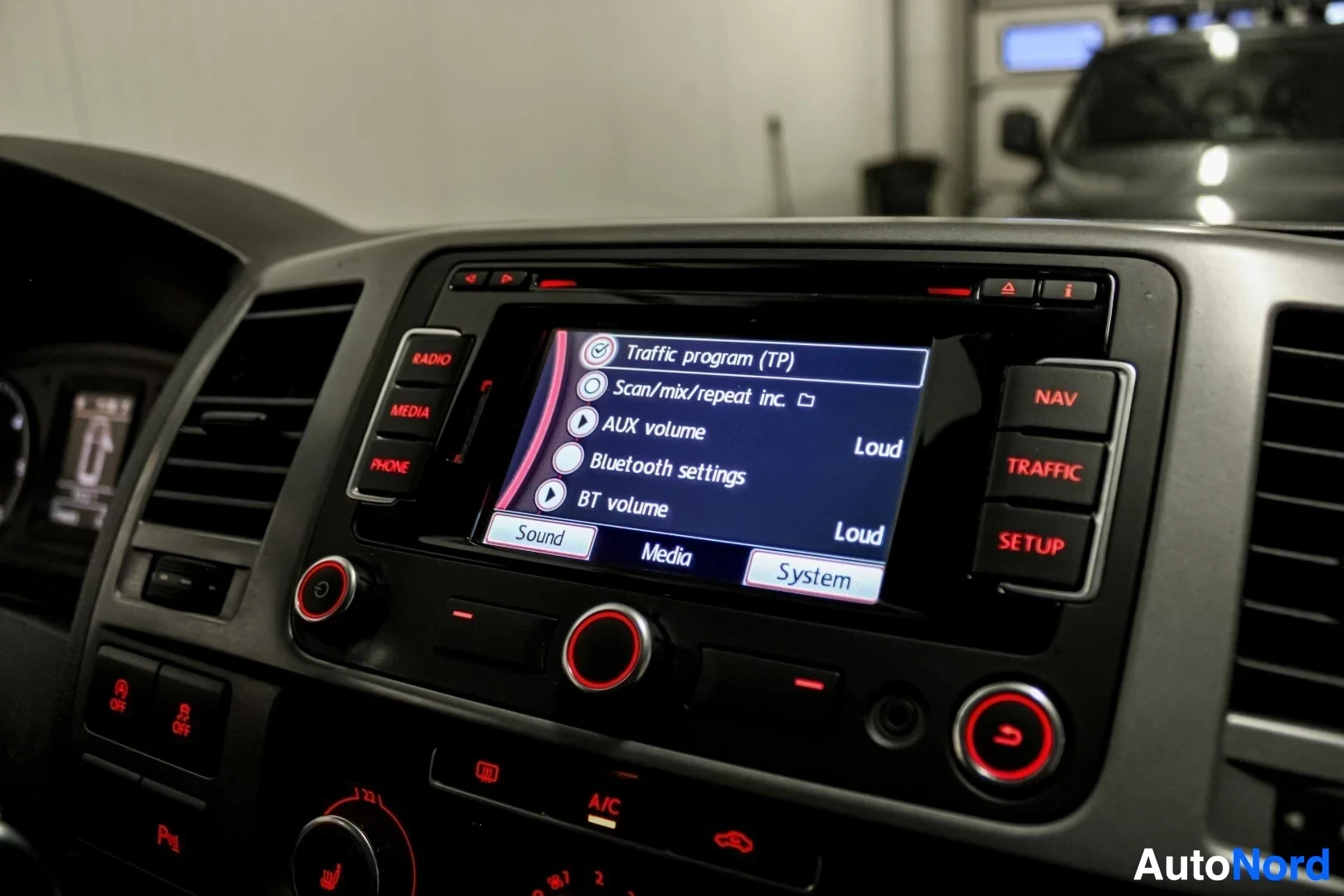 Ohjaamo: Lähikuva auton keskinäytöstä, jossa on Bluetooth-asetukset valittuna. Valikossa näkyy myös 'Traffic program (TP)', 'AUX volume' ja 'BT volume'.