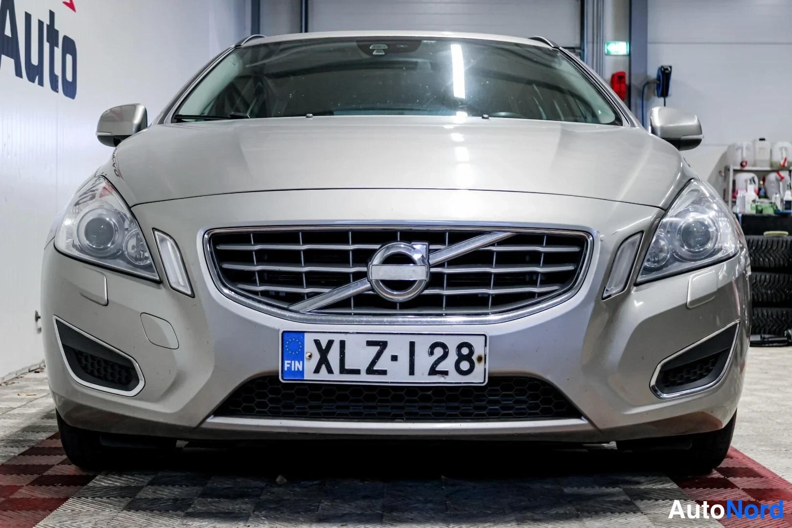 Edestä: Volvo V60 -farmarin keula kuvattuna suoraan edestä: etusäleikkö, ajovalot ja etupuskuri näkyvät, rekisterikilpi lukee.